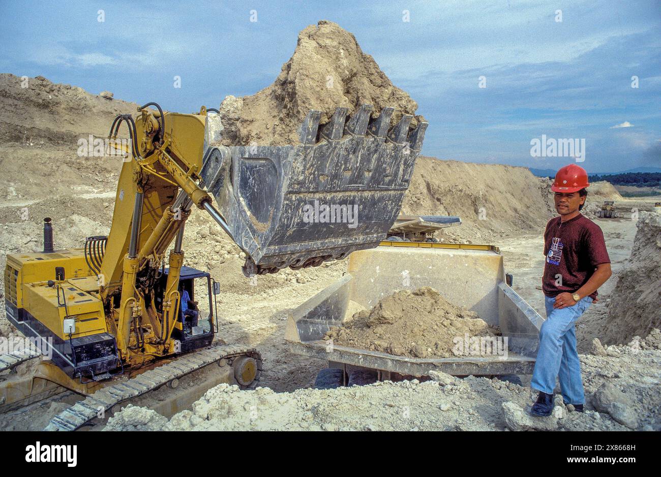 Philippinen, Mindenao; Bergmann und Bagger in einem Kalksteinbruch. Stockfoto