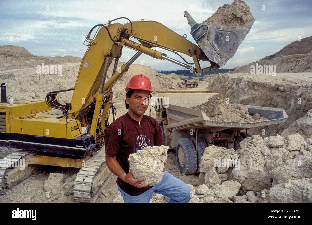 Philippinen, Mindenao; Bergmann und Bagger in einem Kalksteinbruch. Stockfoto