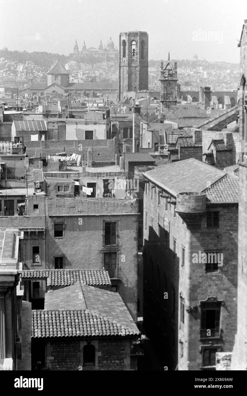 Blick über die Altstadt von Barcelona vom Turm der Kathedrale von Barcelona, erkennbar der Glockenturm der Kirche Santa María del Pino sowie im Hintergrund der Palau Nacional auf dem Berg Montjüic, Spanien 1957. Blick über die Altstadt von Barcelona vom Turm der Kathedrale von Barcelona, mit dem Glockenturm der Kirche Santa María del Pino und dem Palau Nacional auf dem Berg Montjüic im Hintergrund, Spanien 1957. Stockfoto