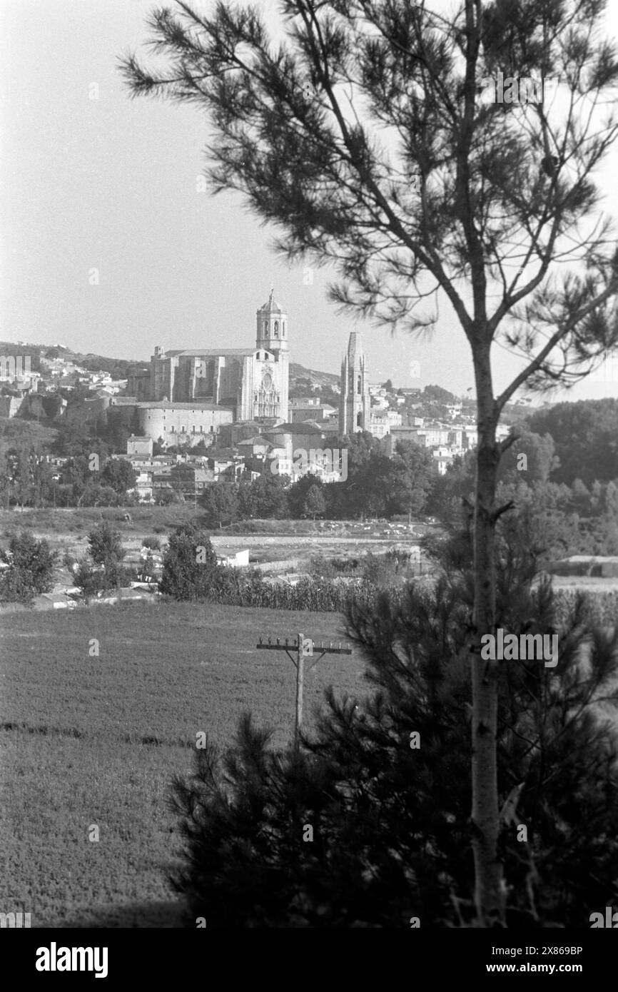 In die Landschaft eingebettet liegt die Kathedrale von Girona und der Glockenturm von Sankt Felix, Spanien 1957. Eingebettet in die Landschaft ist die Kathedrale von Girona und der Glockenturm von St. Felix, Spanien 1957. Stockfoto