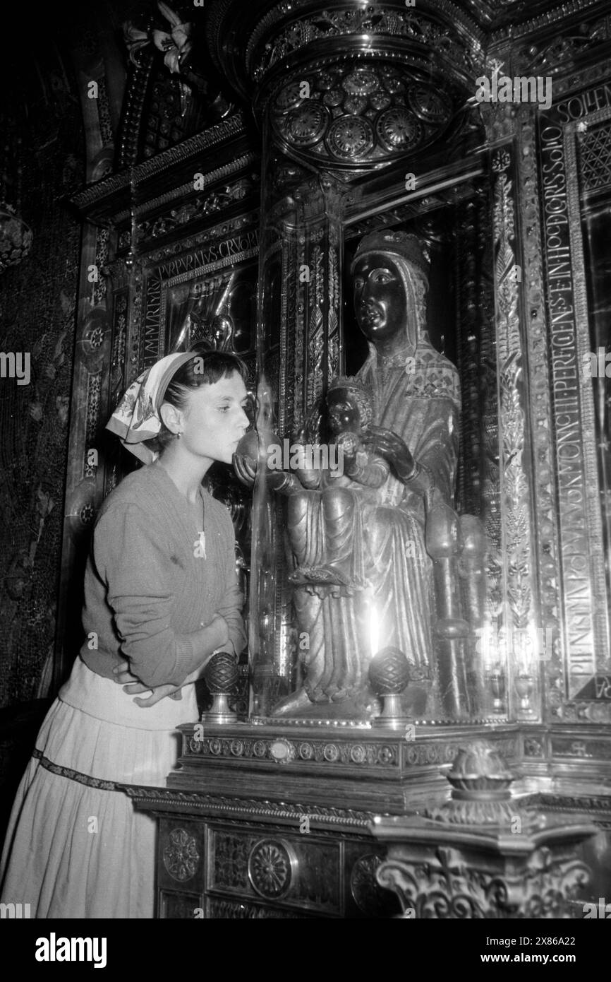 Die Schwarze Madonna von Montserrat ist ein beliebtes Ziel von Pilgern und Bittstellern, die Universumskugel in der rechten Hand der Figur berühren oder küssen, Montserrat 1957. Die Schwarze Madonna von Montserrat ist ein beliebtes Ziel für Pilger und Bittsteller, die die Sphäre des Universums in der rechten Hand der Figur, Montserrat 1957, berühren oder küssen. Stockfoto