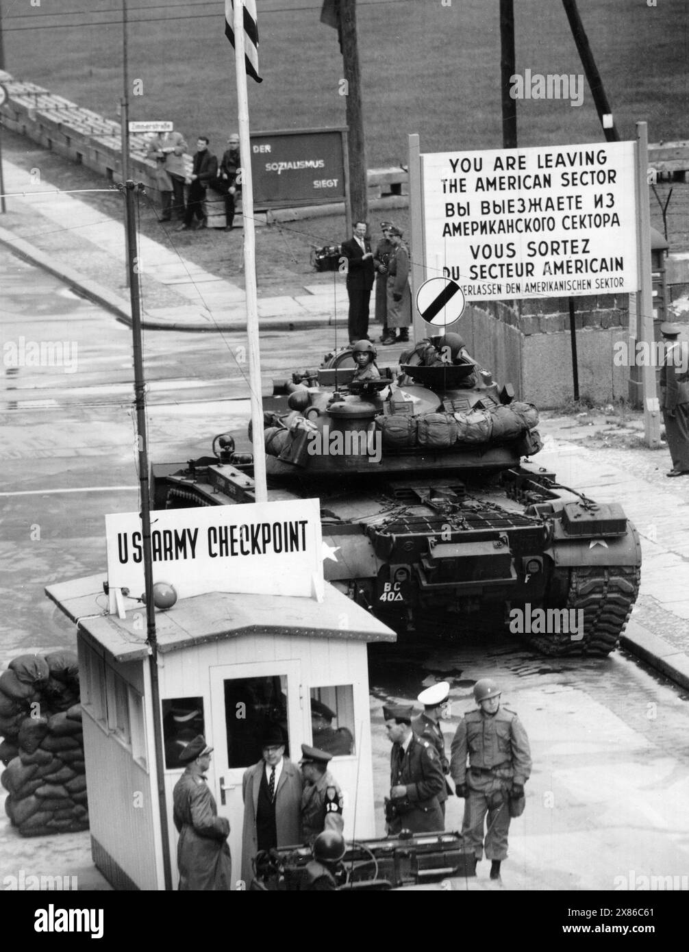 Panzer am Checkpoint Charlie, Berlin 1961. - Originale Bildbeschreibung: 'Übergriffe werden abgewiesen' - zu einem schweren Grenzzwischenfall, kam es auch heute wieder an der Friedrich-/Ecke Kochstraße, als zwei amerikanische Reiseomnibussen die Einfahrt in den sowjetisch-besetzten Sektor verboten werden sollte. Englische und amerikanische Panzertruppeneinheiten bezogen Stellung, um international festgelegte Rechte der vier Besatzungsbehörden zu wahren." Stockfoto