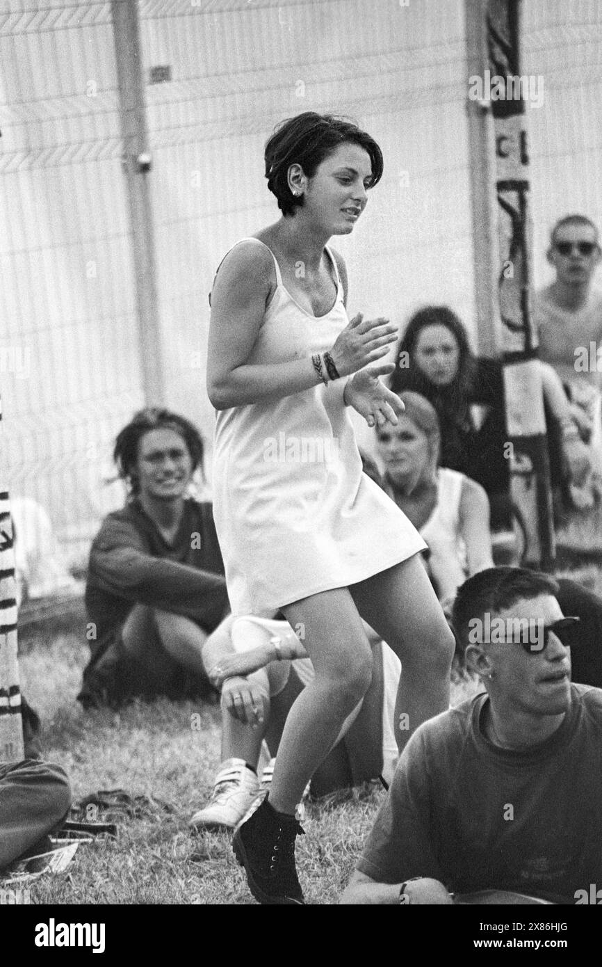 WOMAN DANCING, ACOUSTIC STAGE, GLASTONBURY 94: Eine Frau tanzt in Musik verloren in einem weißen Minikleid, das typisch für die Mode der 90er Jahre ist, auf dem Acoustic Stage Field beim Glastonbury Festival, Pilton Farm, Somerset, England, 26. Juni 1994. Foto: ROB WATKINS Stockfoto