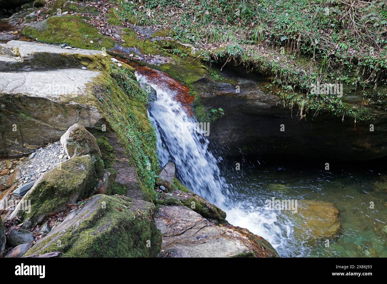 Natürliche Landschaft mit felsigem Wasserfall inmitten eines grünen Regenwaldparks Stockfoto