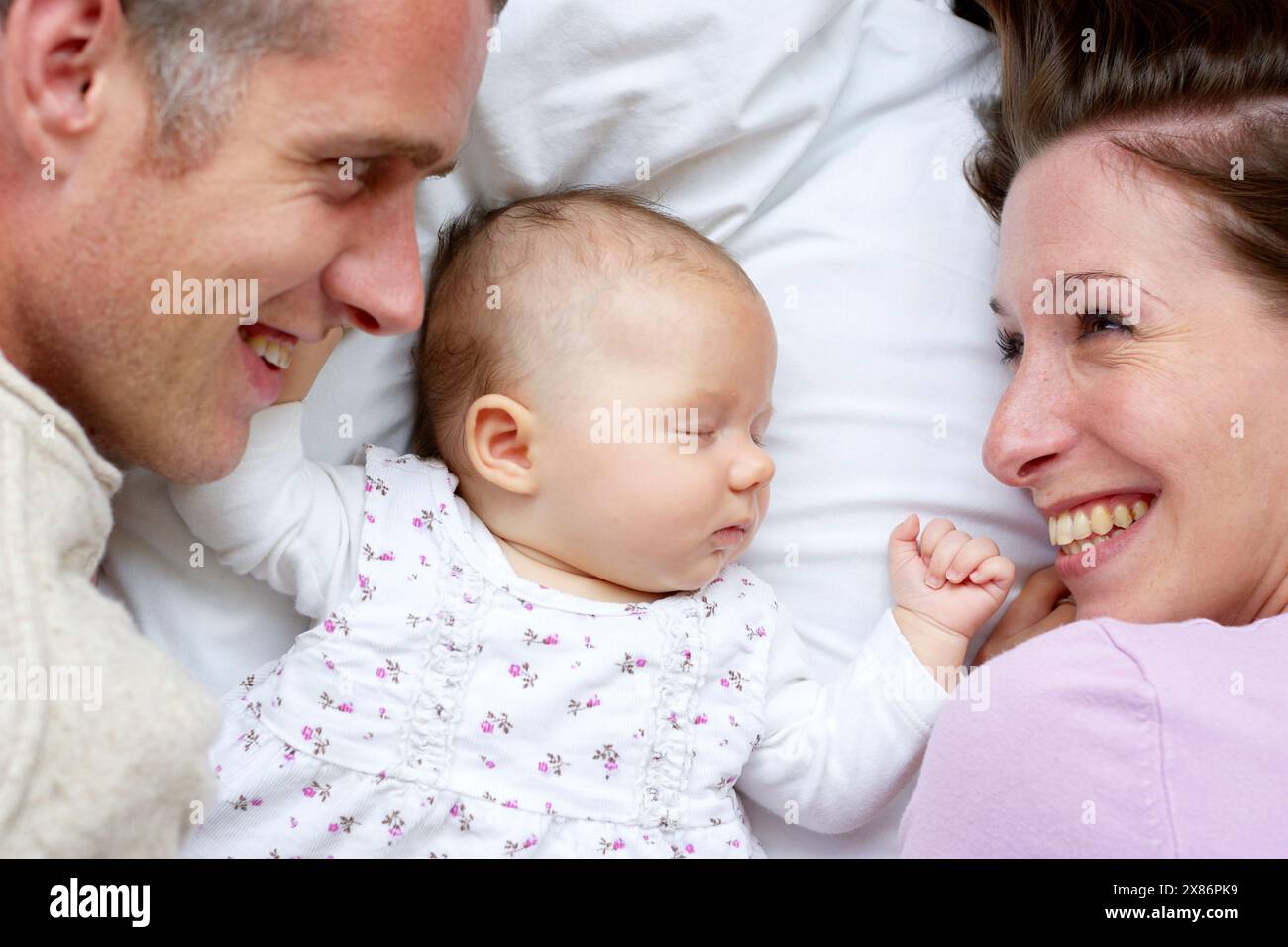 Eltern liegen mit neugeborenem Baby Stockfoto