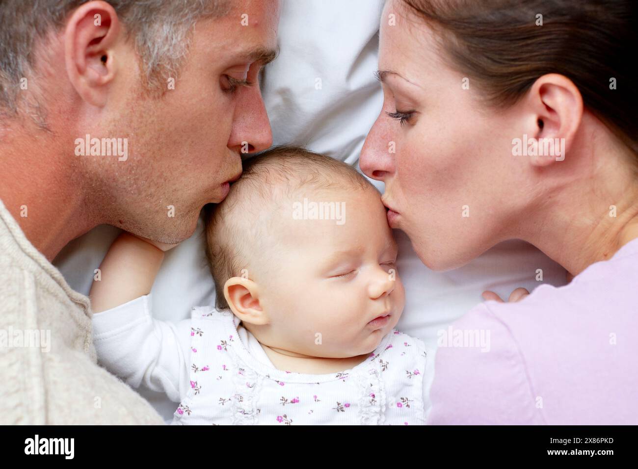 Eltern liegen mit neugeborenem Baby Stockfoto
