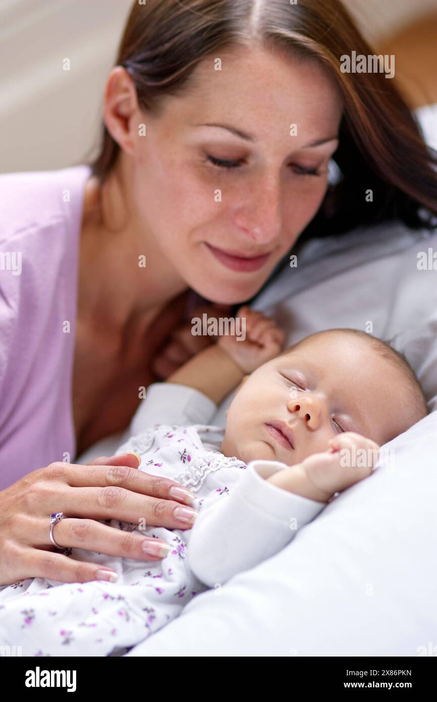 Baby schläft neben Mutter Stockfoto