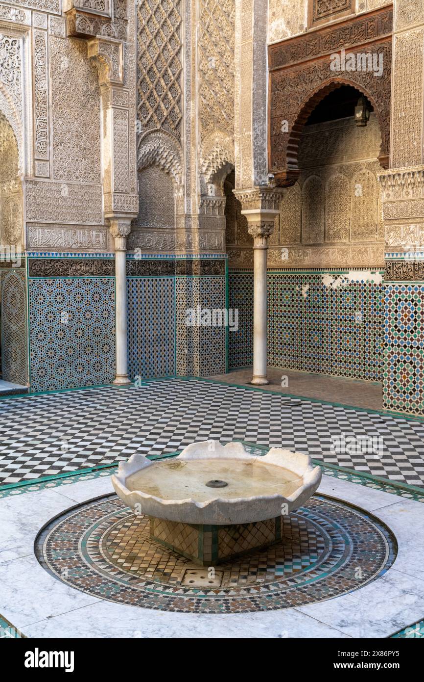 Fès, Marokko - 4. März 2024: Brunnen und Innenhof in der Parfümeurschule Al-Attarine Madrasa in der Innenstadt von Fès Stockfoto