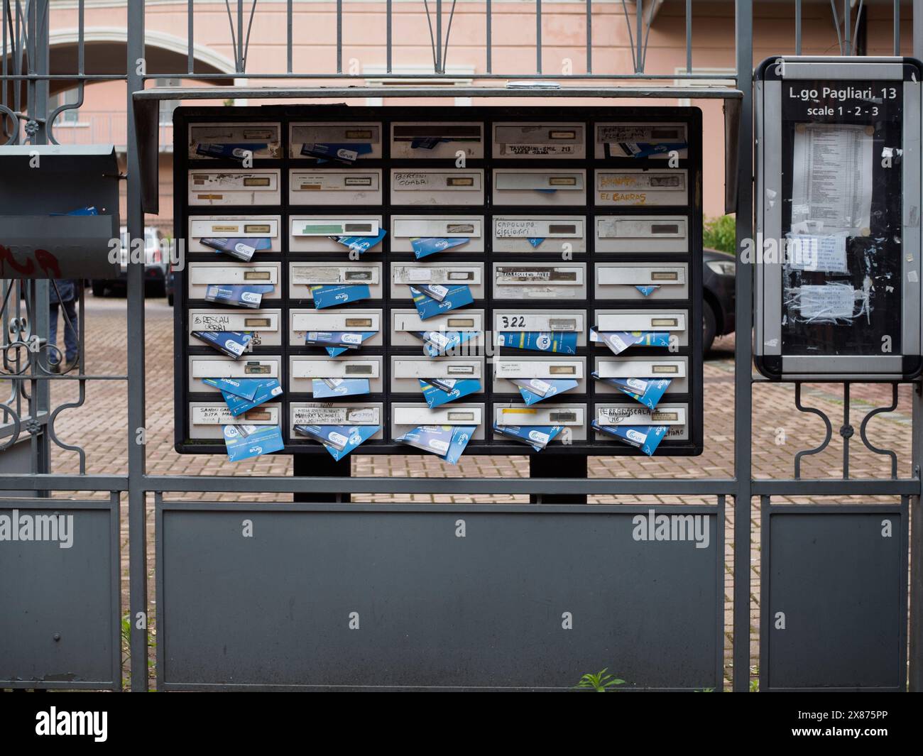 Cremona, Italien - 5. Mai 2024, mehrere Briefkästen gefüllt mit überfüllten Briefen und Anzeigen, die eine gemeinsame Szene in einer Wohnwohnung darstellen Stockfoto