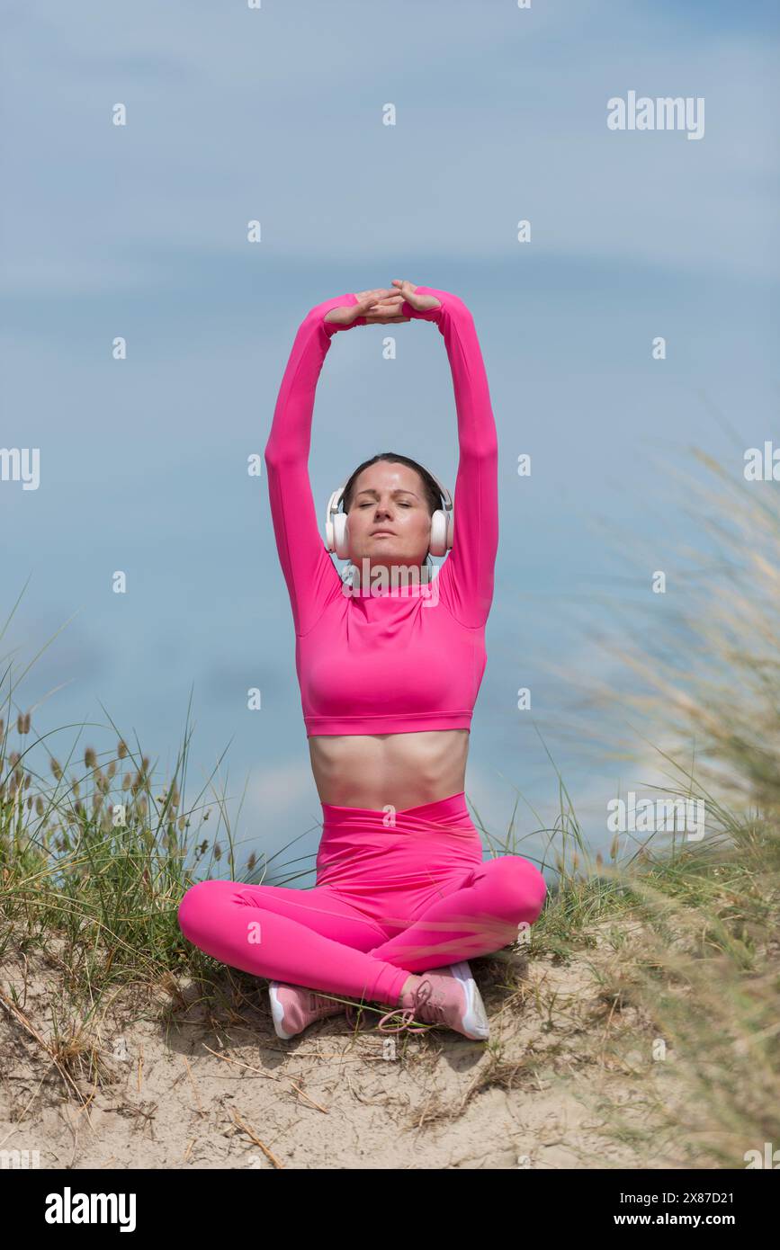 Sportliche Frau in Pink, Meditation und weg von allem. Entspannungskonzept Stockfoto