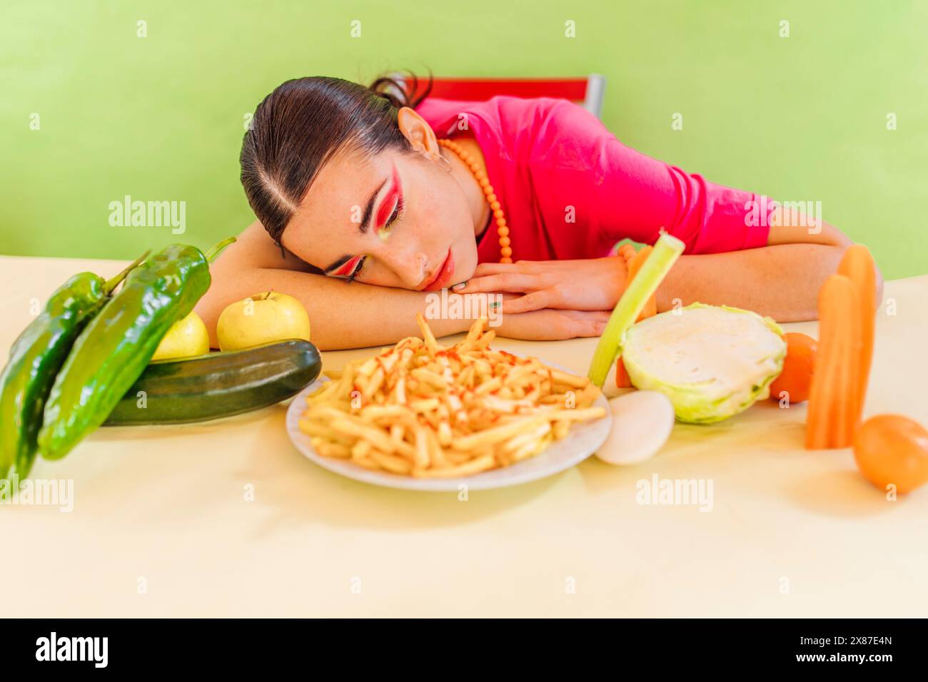 Frau, die auf gesundes und ungesundes Essen auf dem Tisch schaut Stockfoto