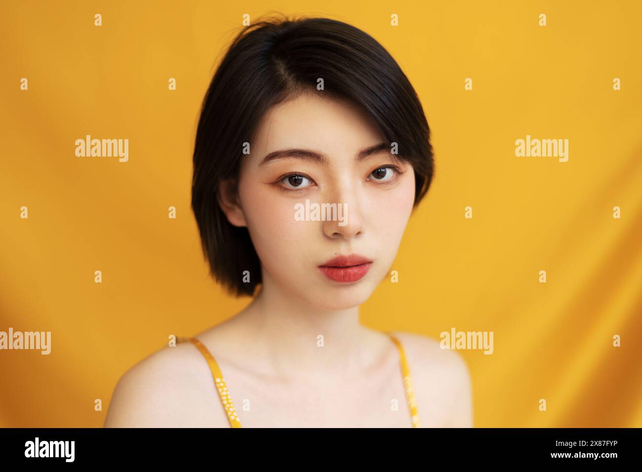 Schöne Frau mit kurzen Haaren auf gelbem Hintergrund Stockfoto