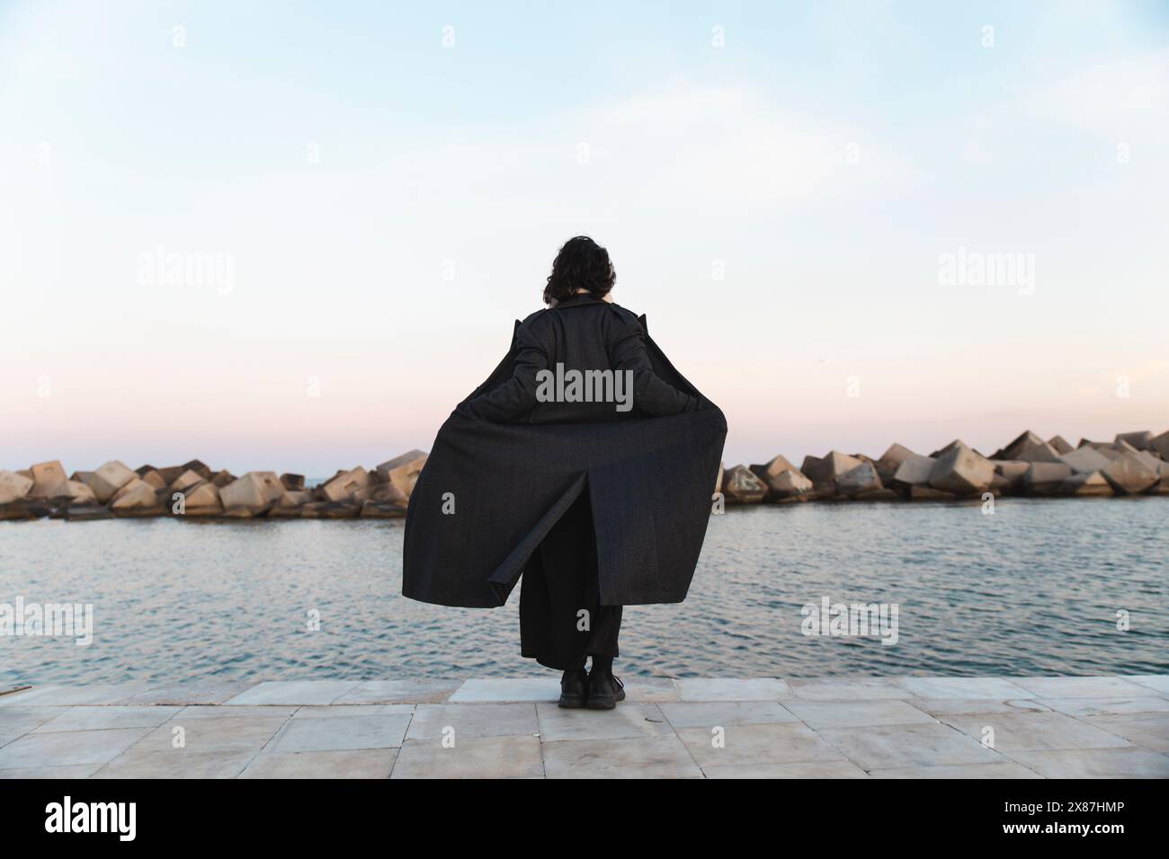 Sorglose Frau, die auf der Promenade zum Meer hin steht Stockfoto