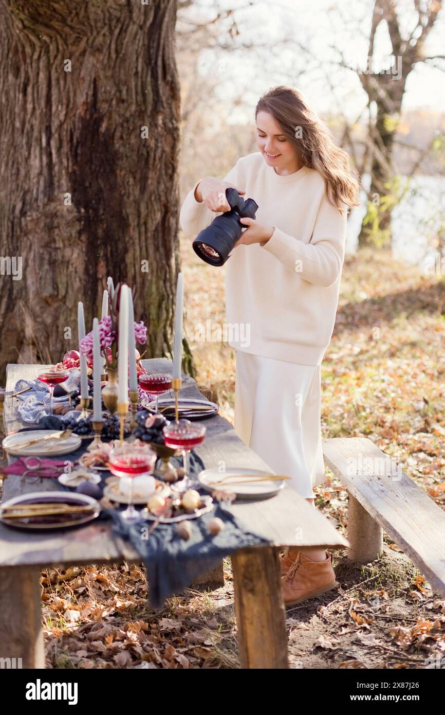 Schöne Frau klickt Fotos durch die Kamera im Wald Stockfoto