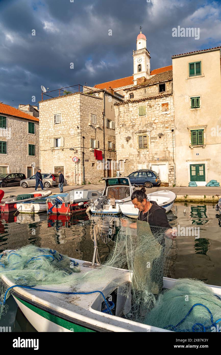 Fischer in Sibenik Fischer mit Netz auf seinem Boot im kleinen Hafen in der Altstadt von Sibenik, Kroatien, Europa *** Fischer in Sibenik Fischer Stockfoto