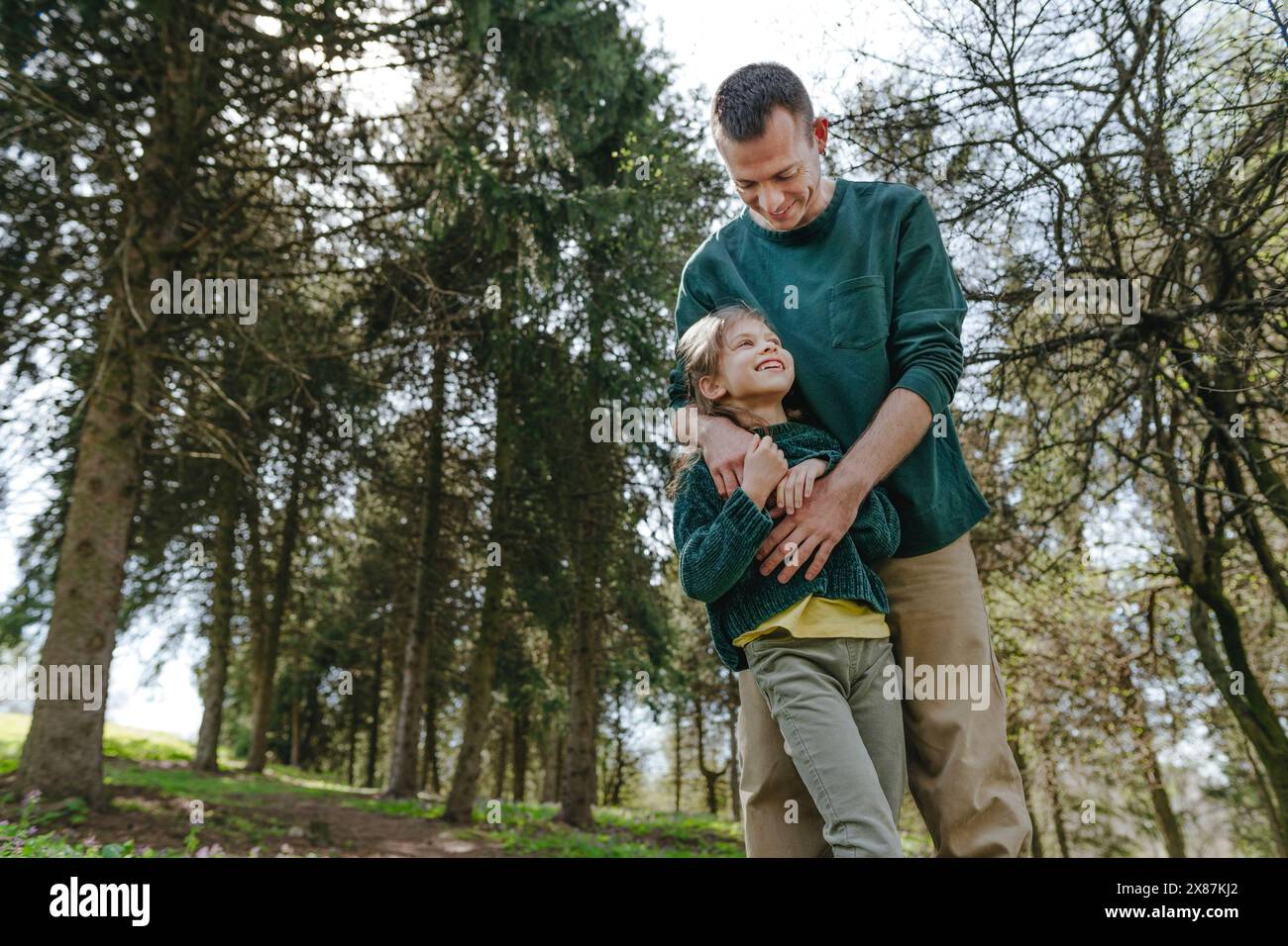 Vater spielt mit Tochter im Wald Stockfoto