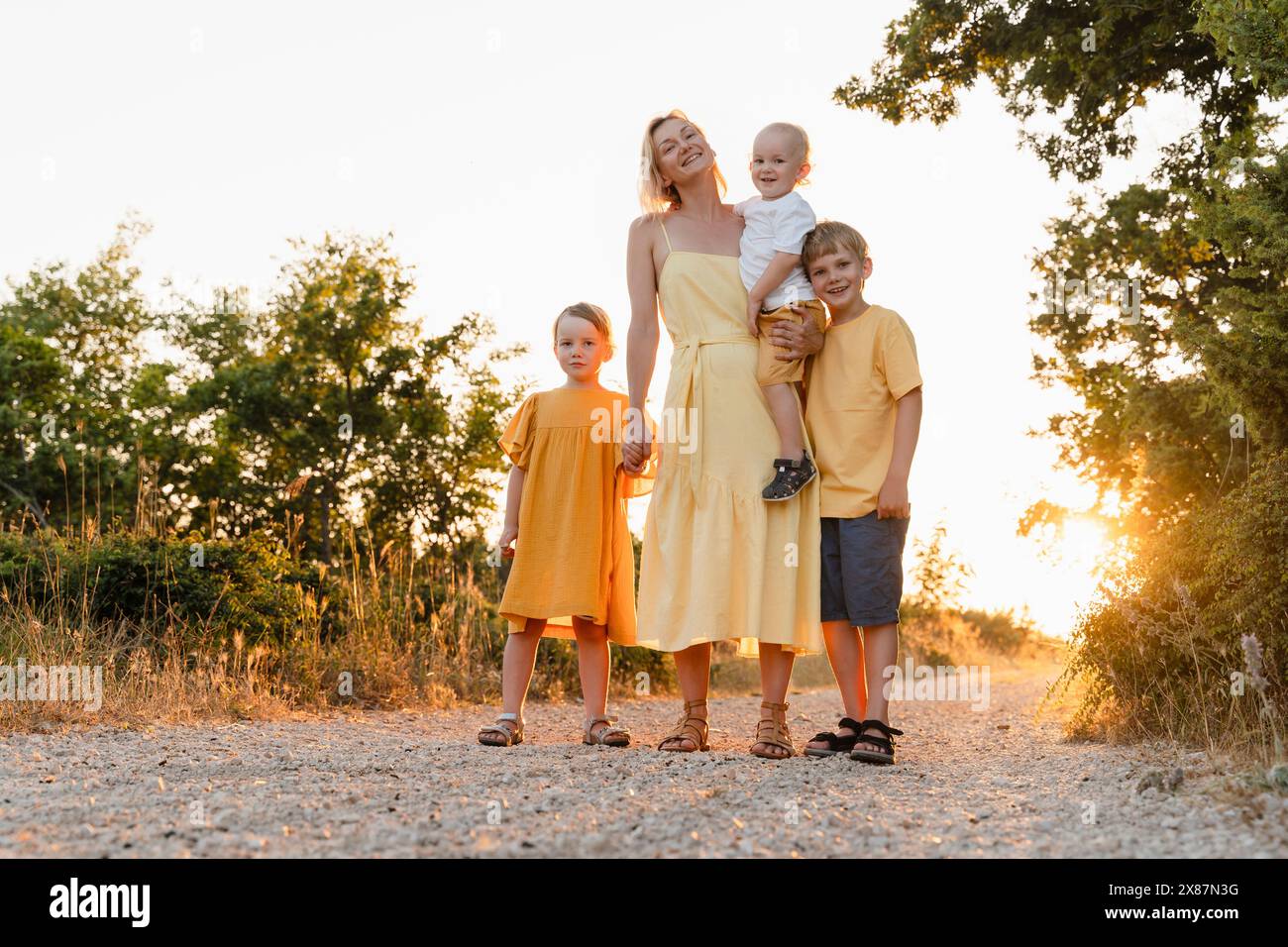 Mutter mit drei Kindern, die auf dem Fußweg stehen Stockfoto