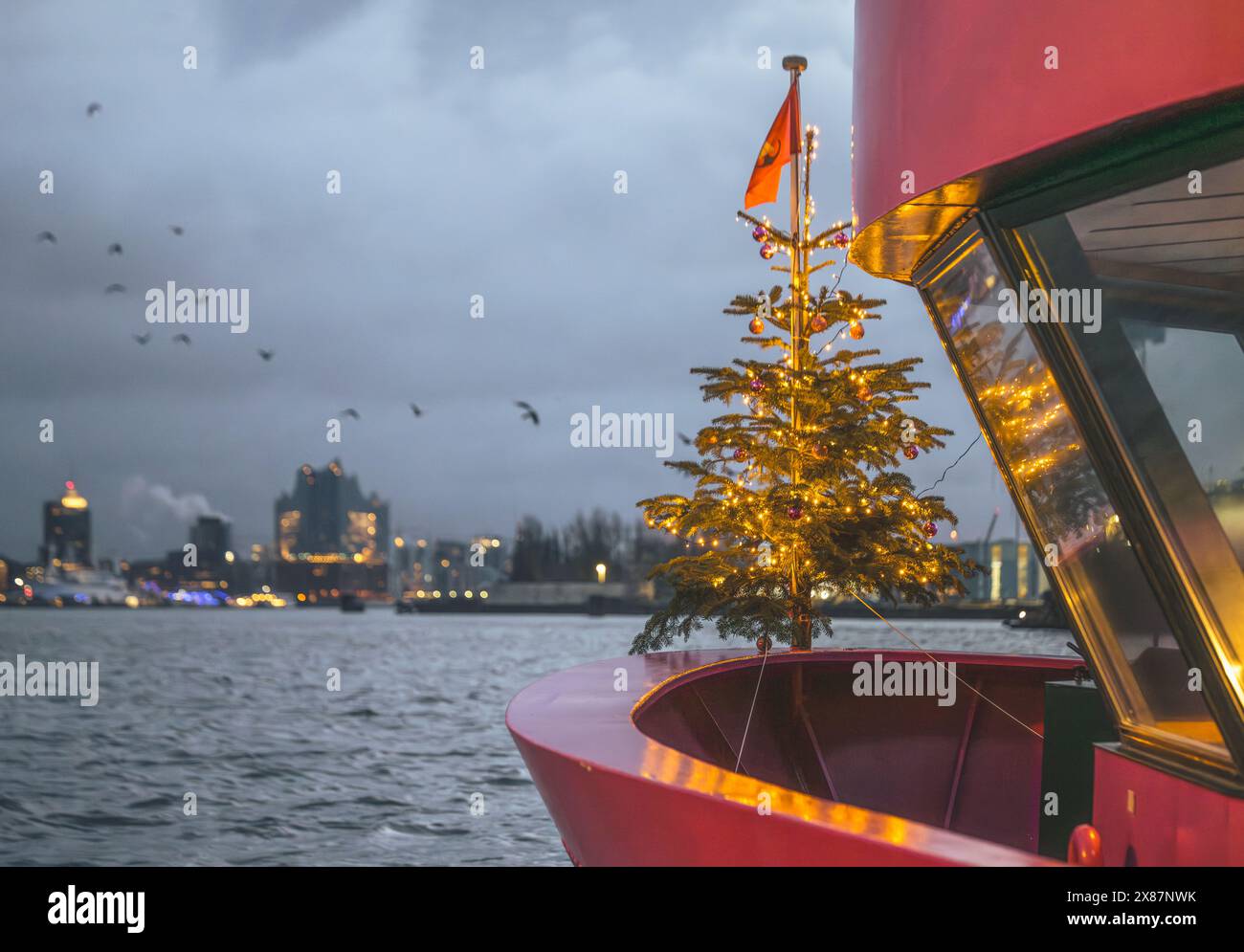 Deutschland, Hamburg, Weihnachtsbaum, der hinter der Fähre leuchtet Stockfoto