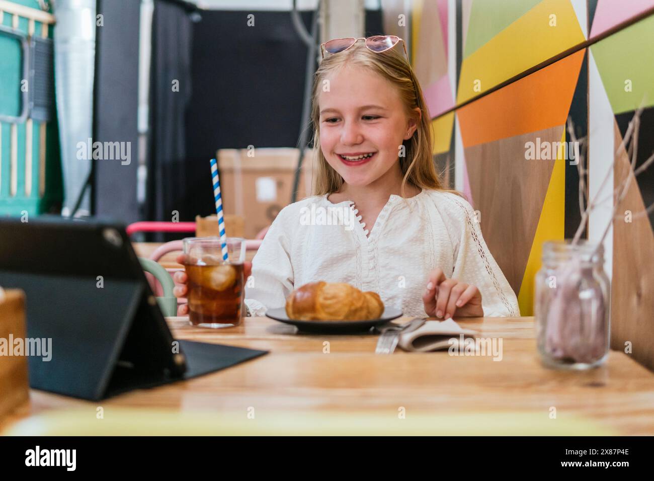 Happy Girl, das sich Filme auf einem Tablet-PC im Restaurant ansieht Stockfoto