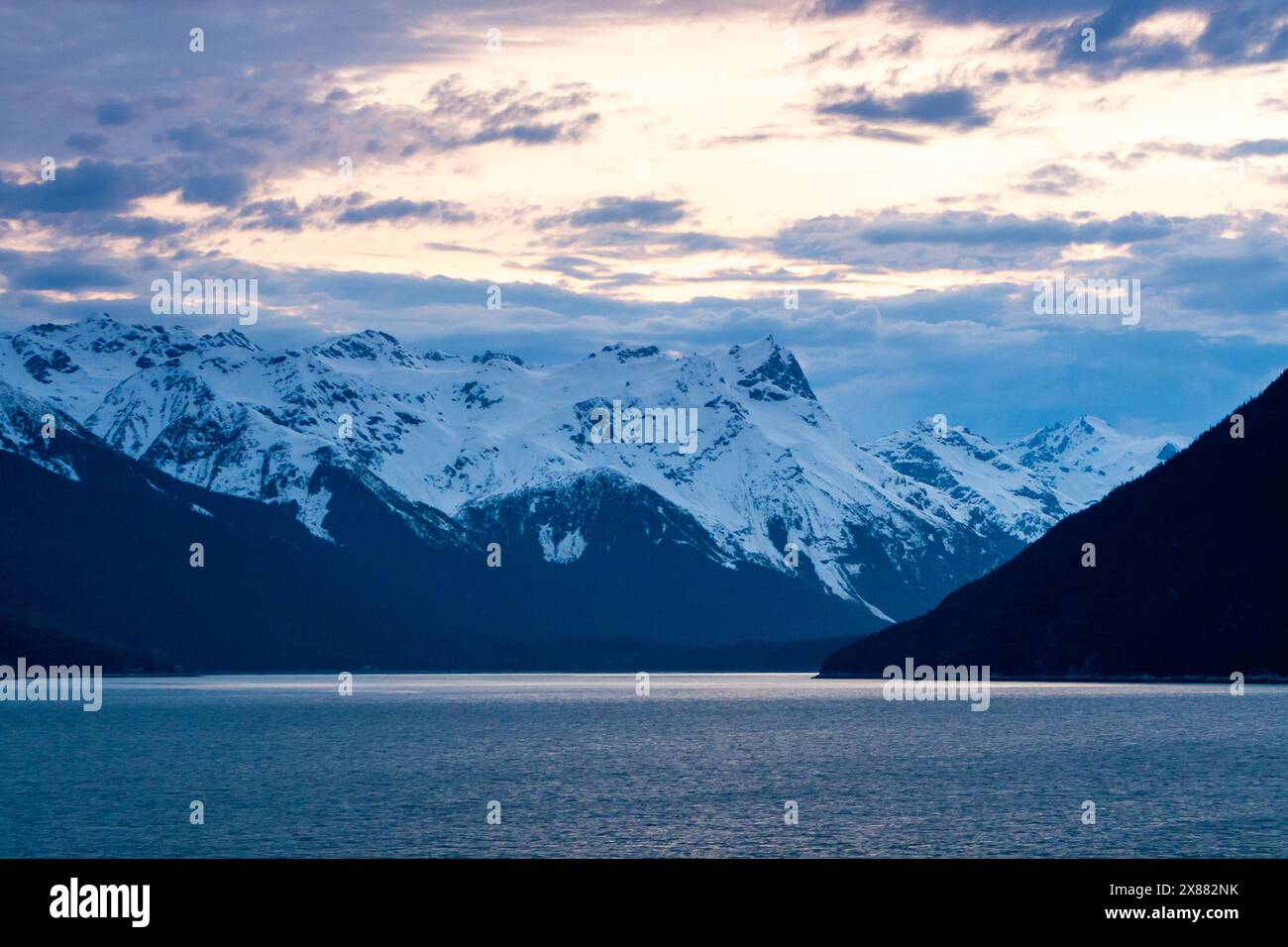 Schneebedeckte Berge in der Abenddämmerung entlang des Chilkoot Inlet bei Haines, Alaska Stockfoto