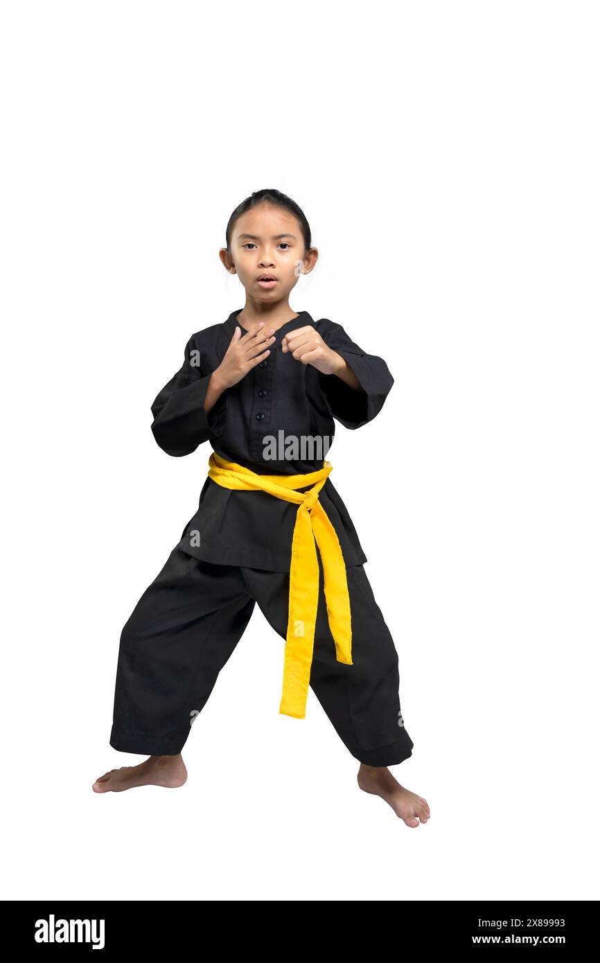 Selbstbewusstes junges Mädchen, das eine Karate-Kampfhaltung demonstriert. In schwarzer Uniform mit gelbem Gürtel. Isoliert auf weißem Hintergrund Stockfoto