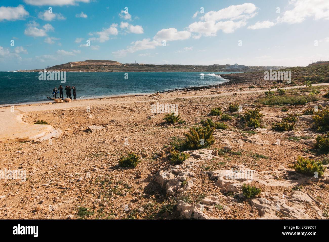 Taucher rüsten sich an den zerklüfteten Ufern des Qawra Point Beach, St. Paul's Bay, Malta Stockfoto
