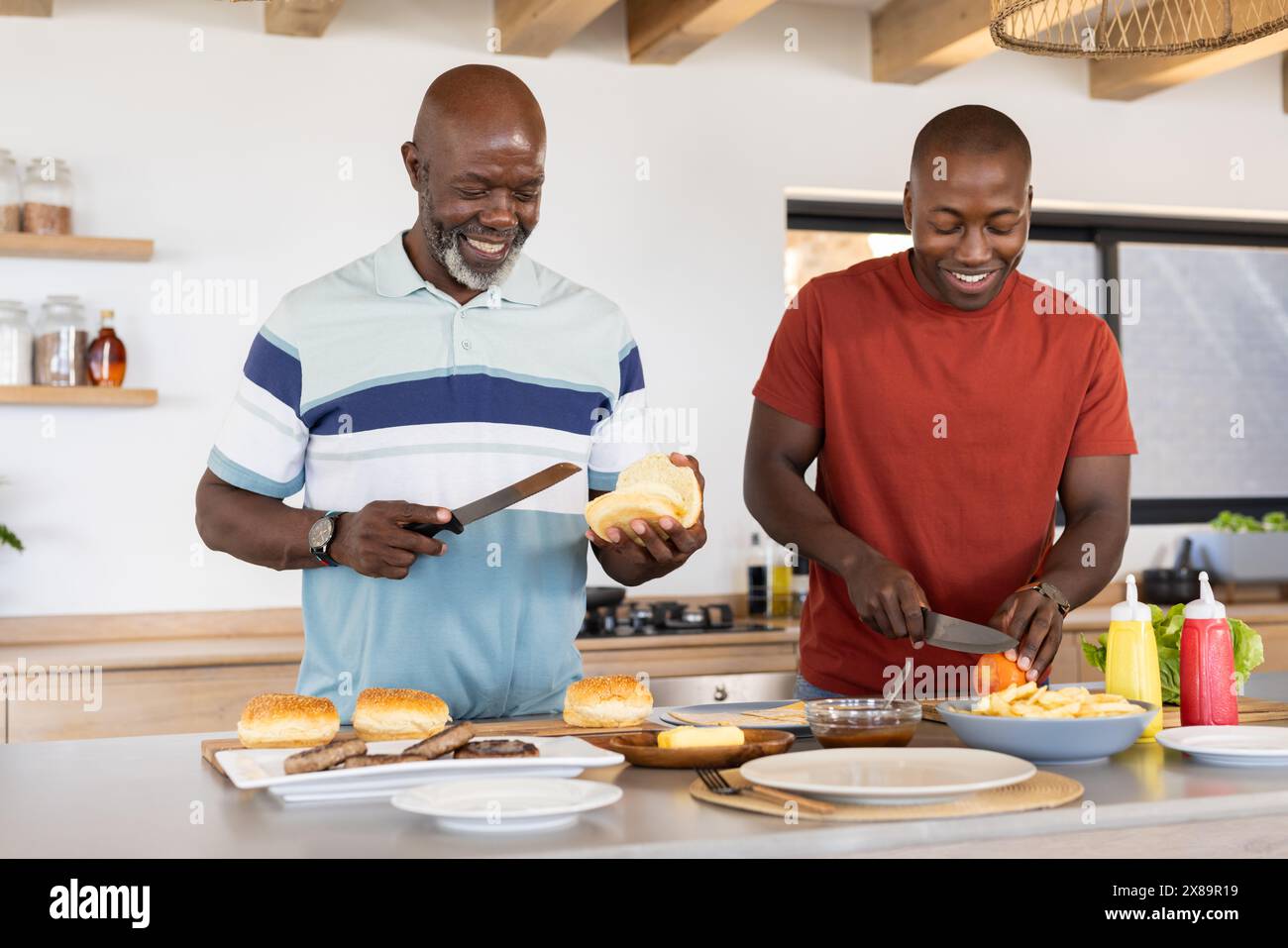 Ein afroamerikanischer Seniorenvater und ein erwachsener Sohn, der zu Hause Essen zubereitete Stockfoto