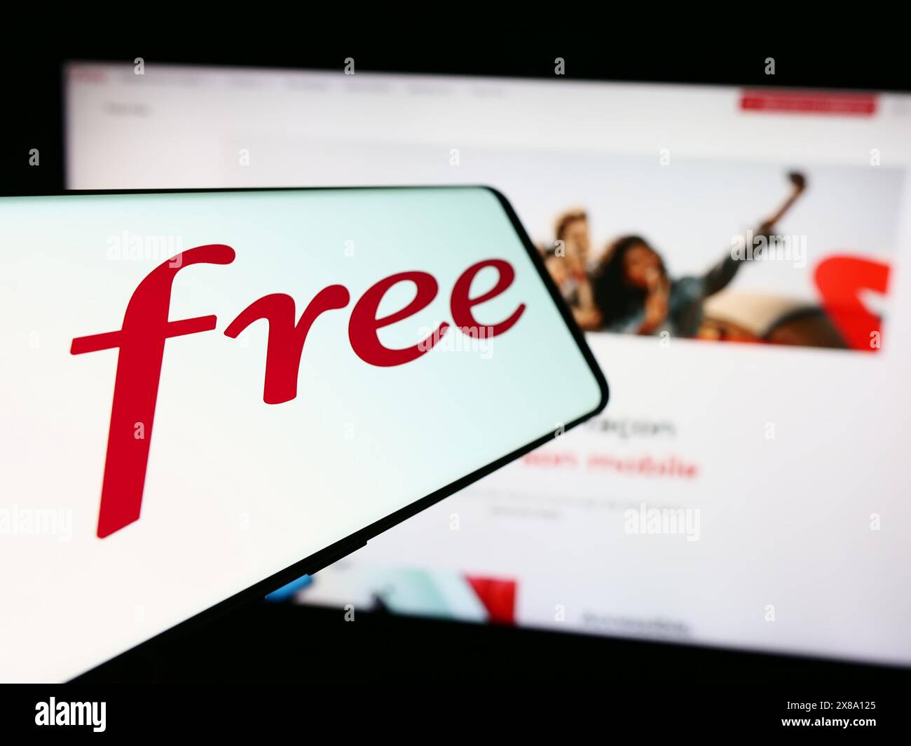 Mobiltelefon mit Logo des französischen Telekommunikationsunternehmens Free SAS vor der Business-Website. Fokussieren Sie sich auf die linke Mitte des Telefondisplays. Stockfoto