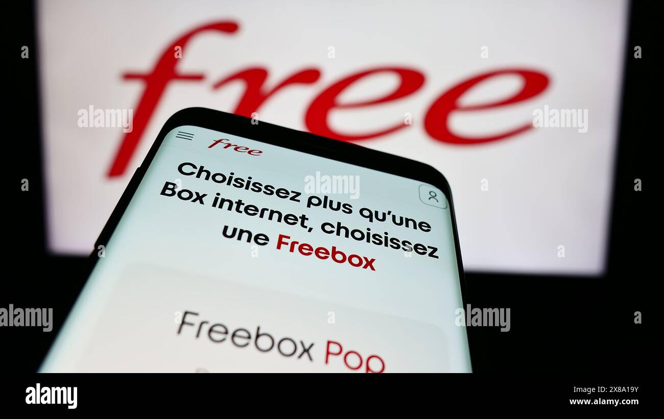 Smartphone mit Website des französischen Telekommunikationsunternehmens Free S.A.S. vor dem Firmenlogo. Fokussieren Sie sich oben links auf der Telefonanzeige. Stockfoto