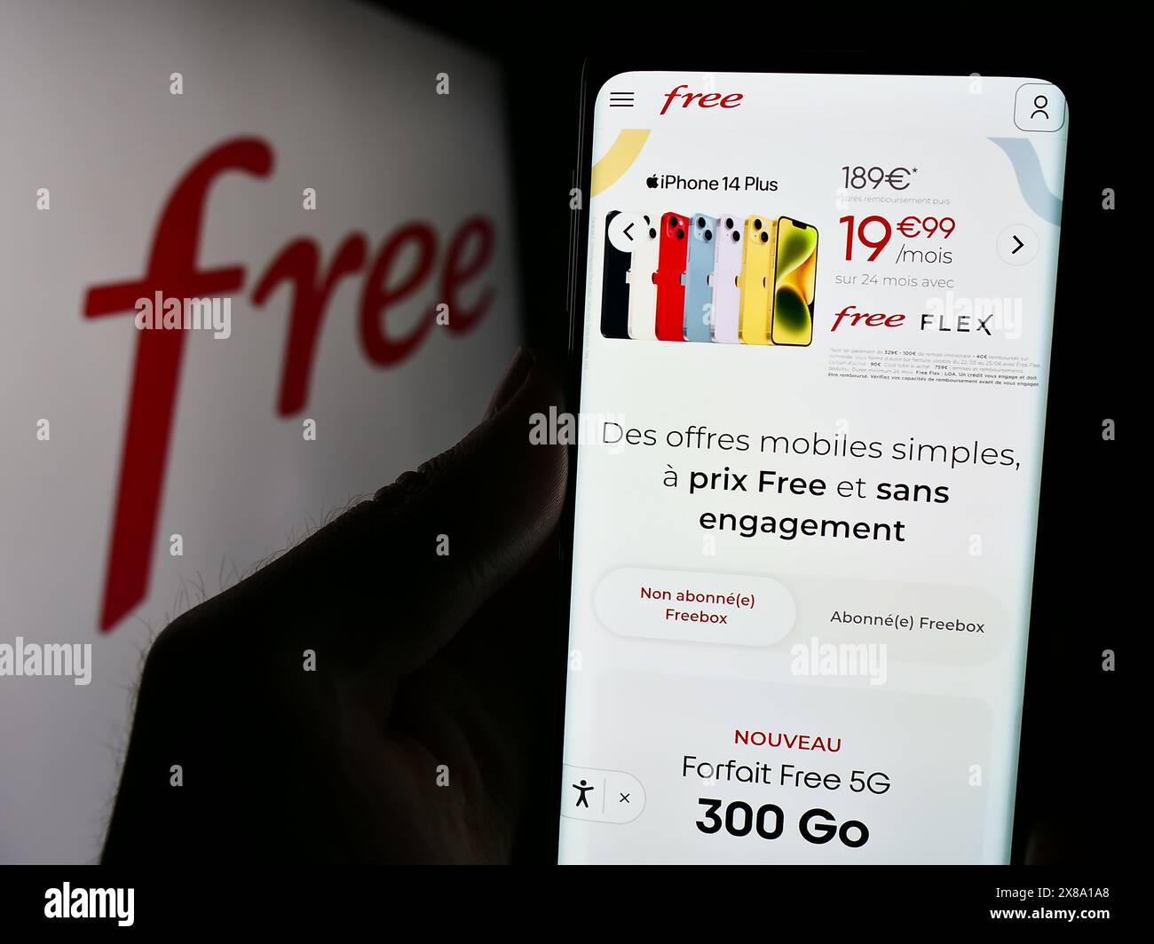 Person, die ein Handy hält, mit der Webseite des französischen Telekommunikationsunternehmens Free S.A.S. vor dem Logo. Konzentrieren Sie sich auf die Mitte des Telefondisplays. Stockfoto