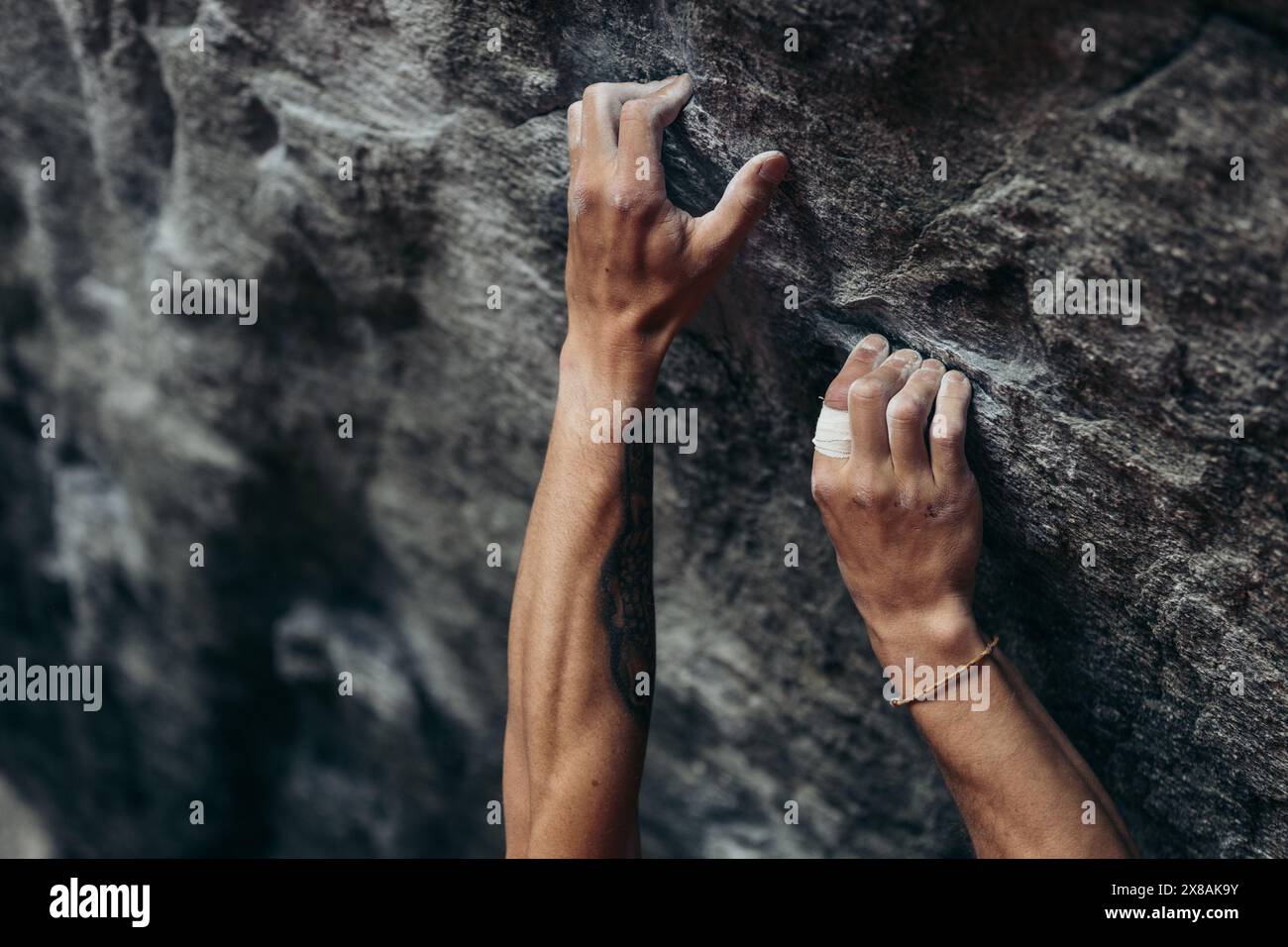 Nahaufnahme der Hände des Kletterers auf rauer Felsoberfläche Stockfoto