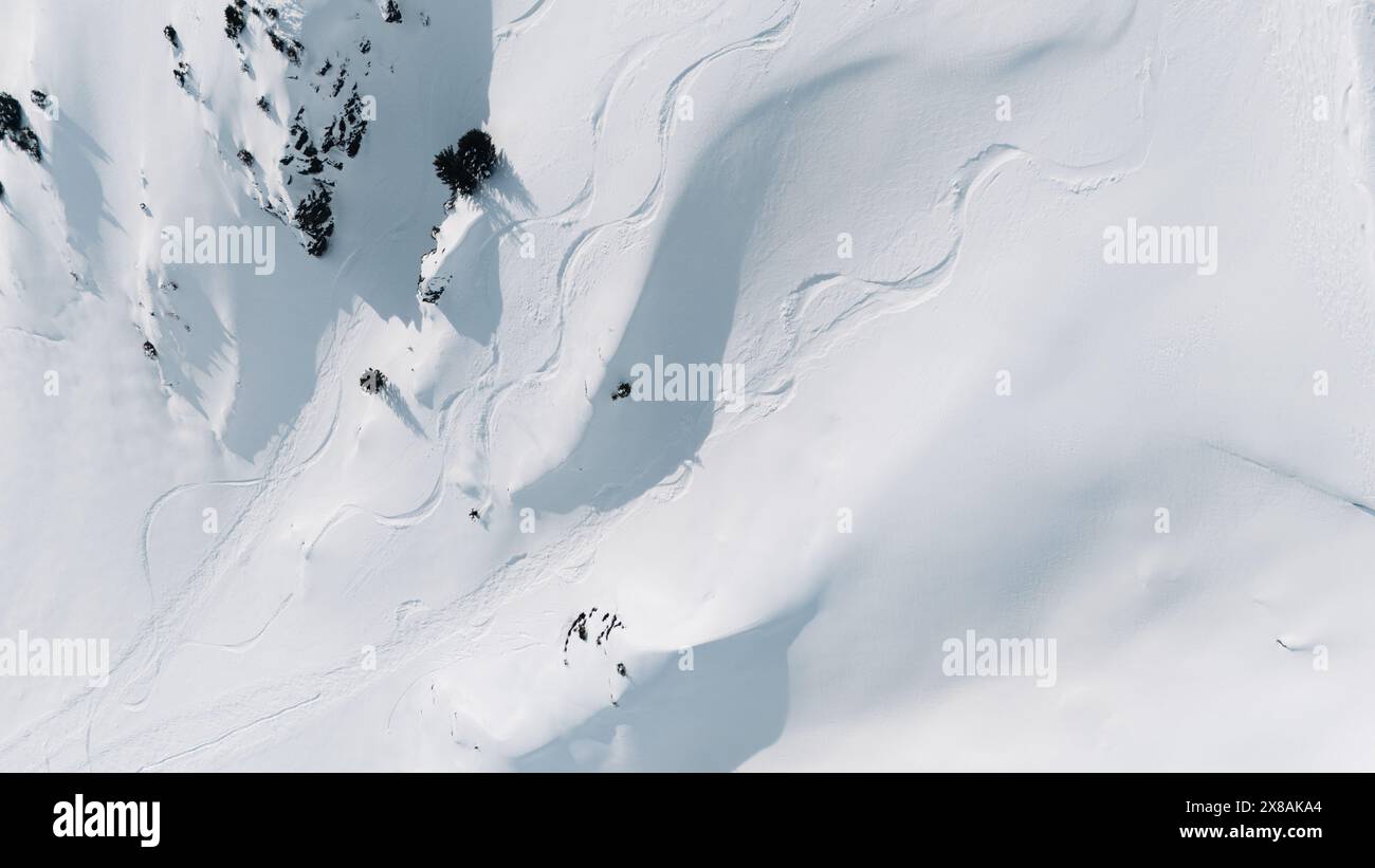 Aus der Vogelperspektive auf die Skipisten und einen Freeskier auf einem verschneiten Berghang Stockfoto