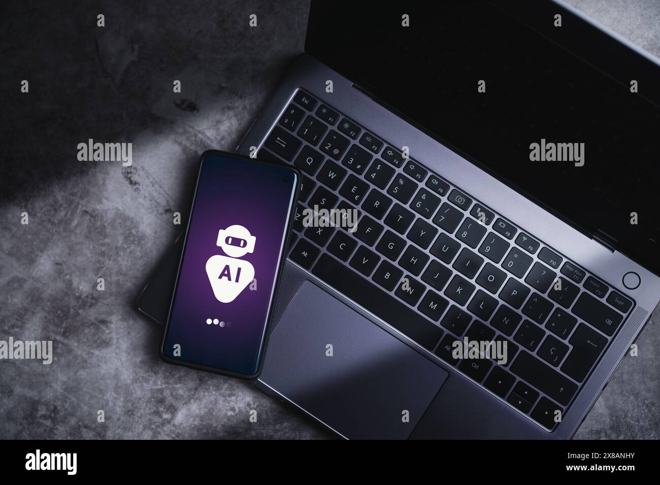 Smartphone liegt auf einem Laptop und zeigt virtuellen Chat mit KI an. Künstliche Intelligenz. Eingabeaufforderung, um etwas zu generieren. Stockfoto