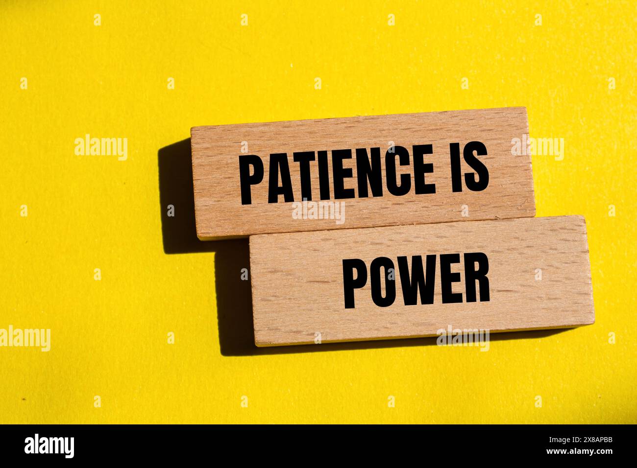 Geduld ist ein Schlagwort auf Holzblöcken mit gelbem Hintergrund. Konzeptionelle Geduld ist ein Machtsymbol. Kopierbereich. Stockfoto