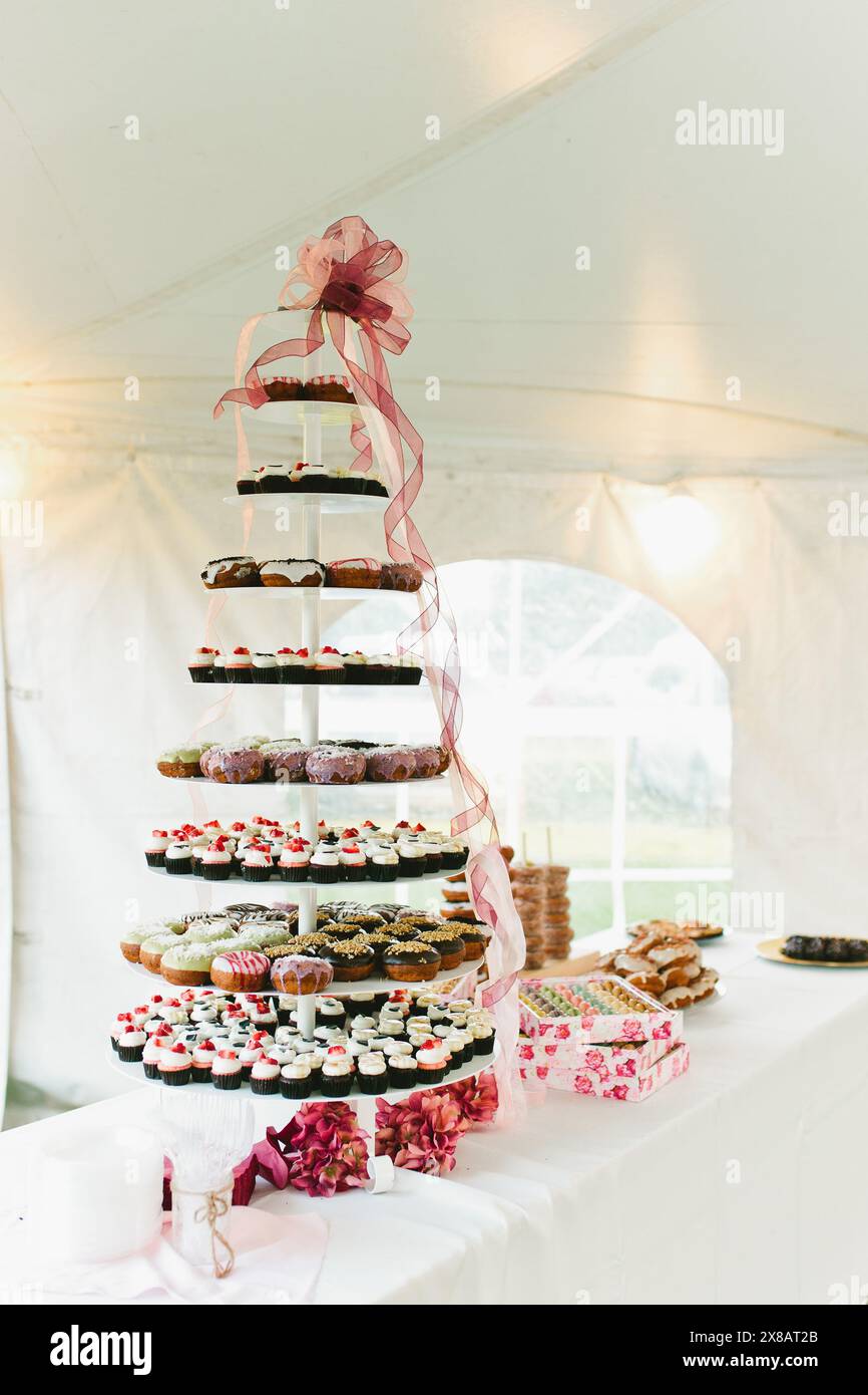 Eiskrapfen- und Erdbeercupcake-Turm am Dessert-Tisch Stockfoto