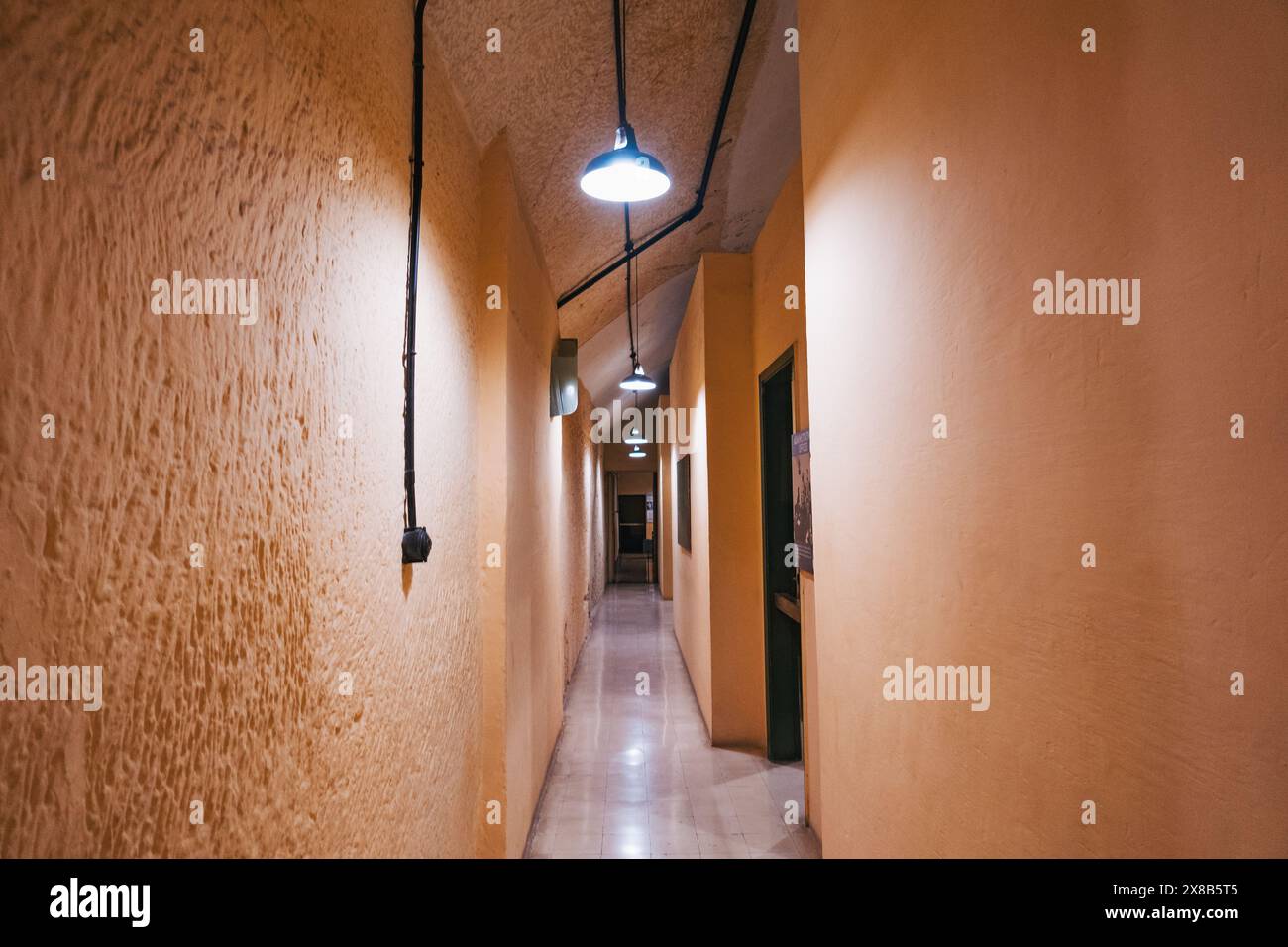 Ein langer, schmaler Flur mit freiliegenden Kabeln und Deckenleuchten in den Lascaris war Rooms in Valletta, Malta Stockfoto