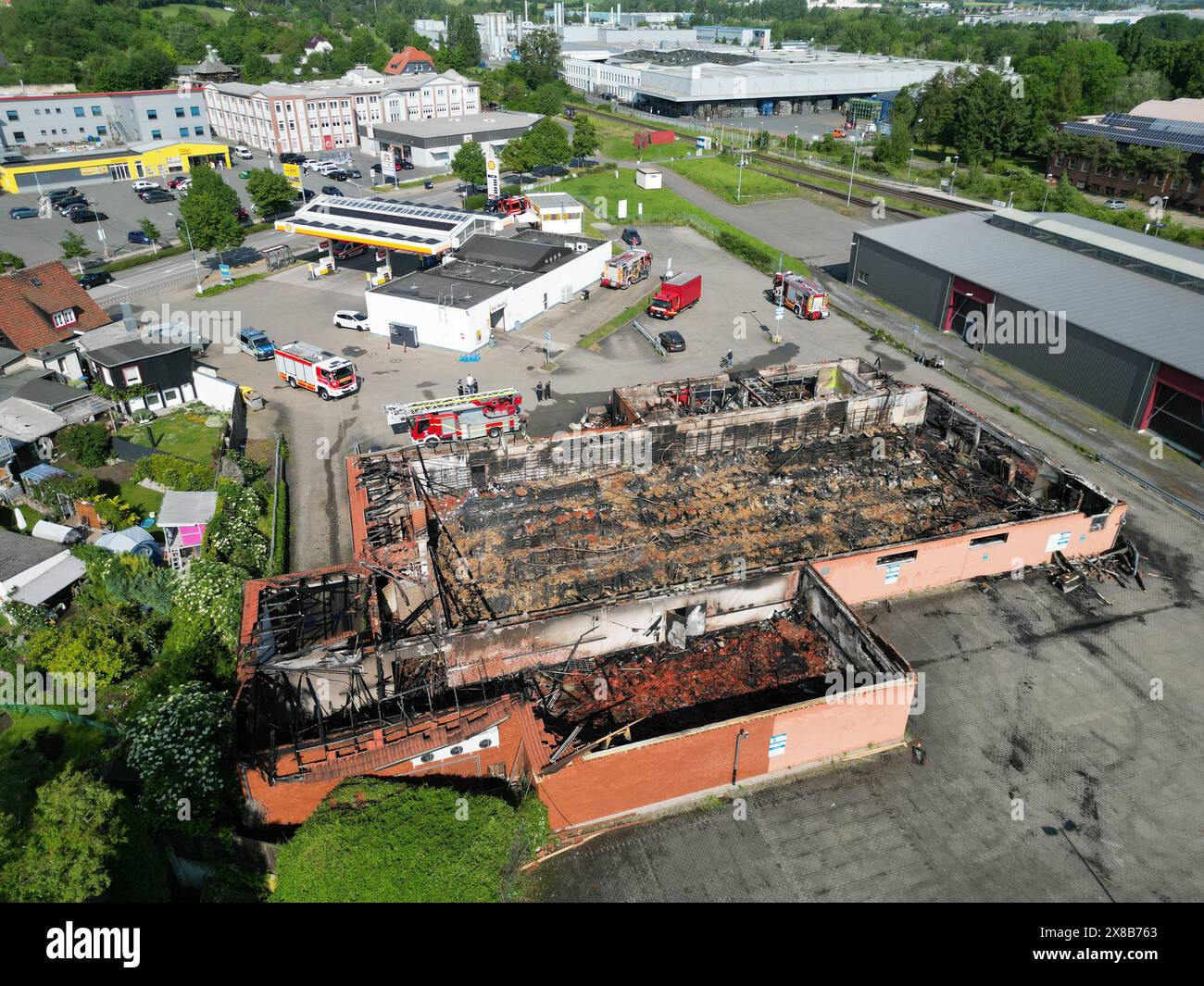 Wernigerode, Deutschland. Mai 2024. Ein 24-Stunden-Geschäft und eine Kebab-Snackbar brannten bis auf den Boden. Das Feuer brach gegen 2,00 Uhr aus. Die Löscharbeiten dauerten mehrere Stunden. Die Feuerwehr wurde mit 100 Feuerwehrleuten eingesetzt und vom Bundesamt für Technische Hilfe (THW) unterstützt. Erste Schätzungen zufolge belaufen sich die Schäden auf über eine Million Euro. Das Gebäude brannte komplett ab. (Aufgenommen mit einer Drohne Credit: Matthias Bein/dpa/Alamy Live News Stockfoto