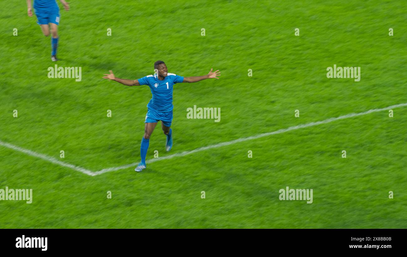 Fußball-Meisterschaftsspiel: Blaues Team: Angreifer laufen glücklich nach dem Siegtor im Turnier feiert der Spieler den Sieg. Sport Channel, Tv Broadcast. Stockfoto