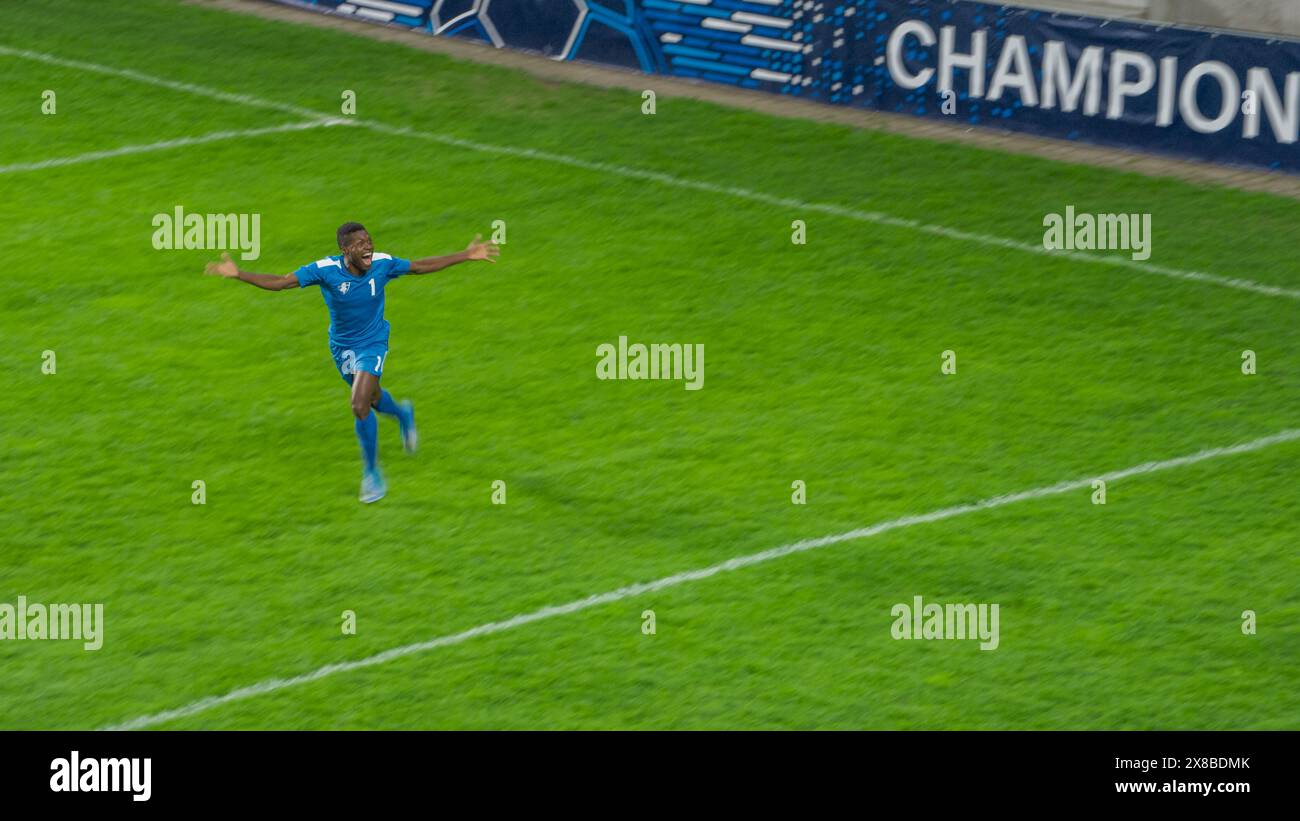 Fußball-Meisterschaftsspiel: Blaues Team: Angreifer laufen glücklich nach dem Siegtor im Turnier feiert der Spieler den Sieg. Sport Channel, Tv Broadcast Concept. Stockfoto