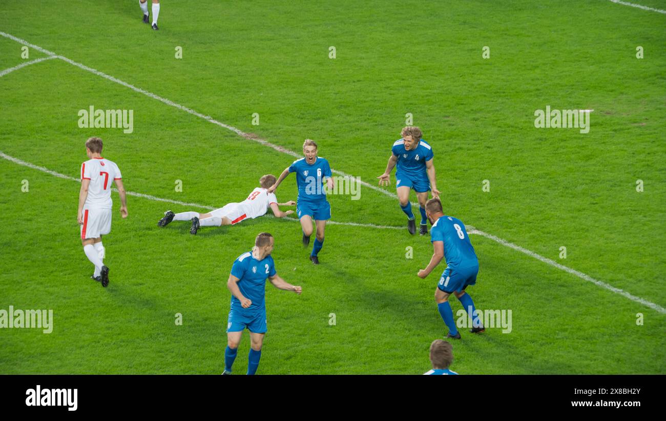 Meisterschaftsspiel: Blue Soccer Football Team Attack, Player Run Happy After Scoring Goal, Celebre Victory, Cheering with Teamkollegen. Sport Channel Broadcast Tv Konzept. Stockfoto