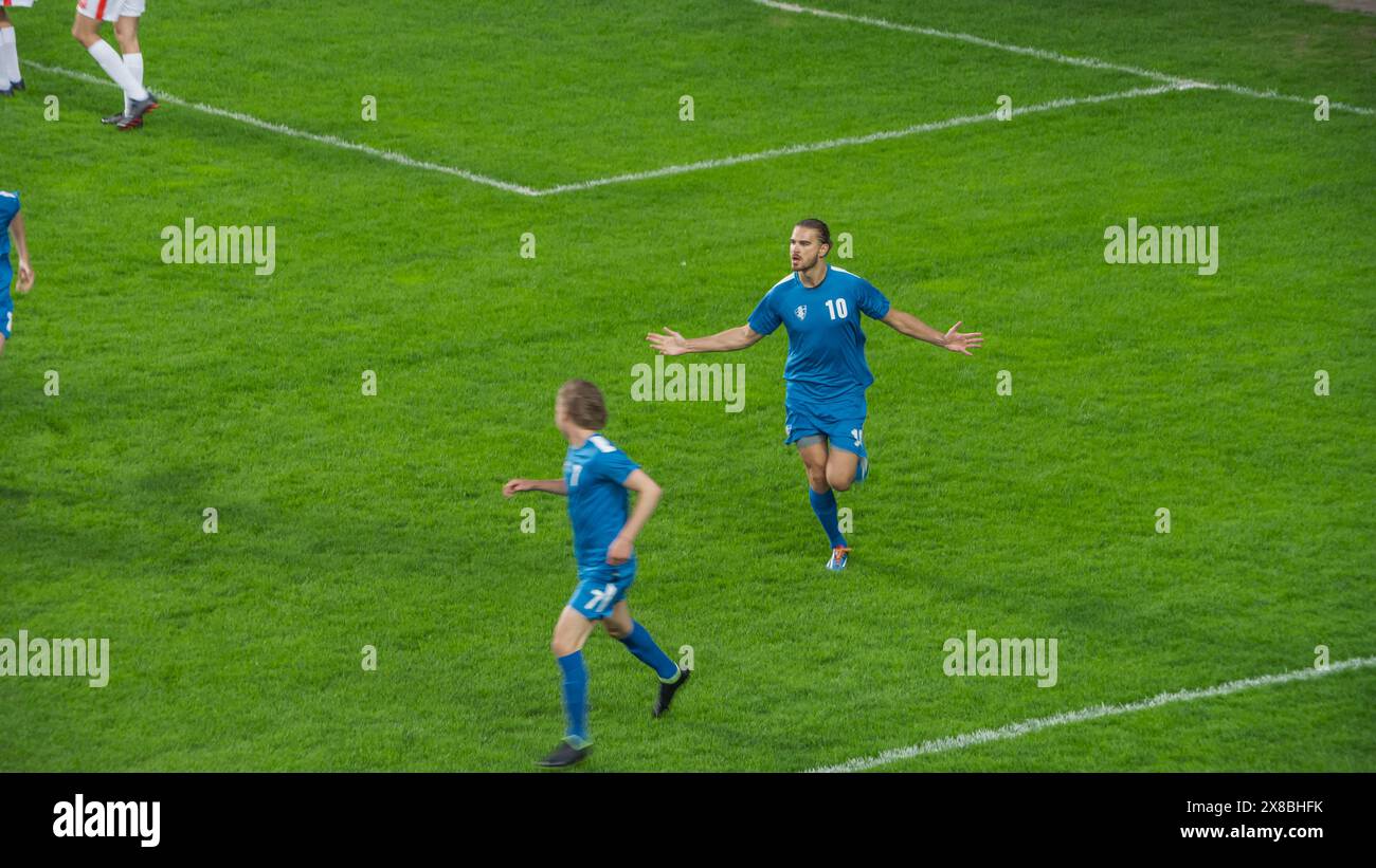 Meisterschaftsspiel: Blue Soccer Team Attack, Player Run Happy After Scoring Goal, Celebre Victory, Cheering mit Teamkollegen auf dem Feld. Sport Channel Broadcast Tv Konzept. Stockfoto