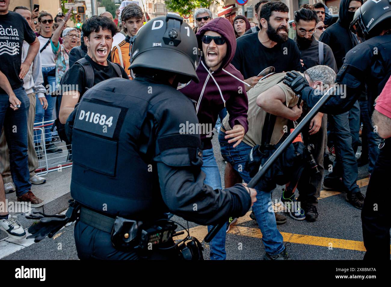 Im Stadtteil Park Güell in Barcelona treffen sich die Bewohner während eines Protests gegen die Louis Vuitton Modenschau mit Polizisten. Die Einwohner Barcelonas versammelten sich um den Park Güell in Barcelona gegen die Louis Vuitton Modenschau und protestierten gegen verschiedene soziale Themen wie Massentourismus, Gentrifizierung, Tierrechte oder die Kommerzialisierung und Privatisierung öffentlicher Räume durch den stadtrat. Stockfoto