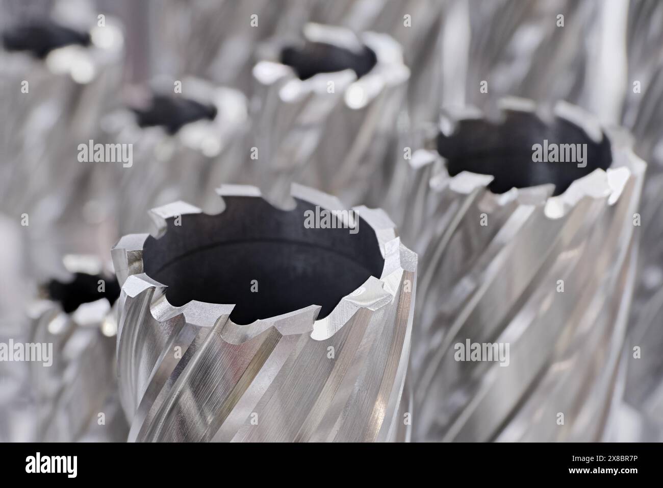 Große Gruppe von verschiedenen Kernschneidern, rotierenden Werkzeugen für die Metallbearbeitung. Nahaufnahme, selektiver Fokus. Abstrakter industrieller Hintergrund. Stockfoto