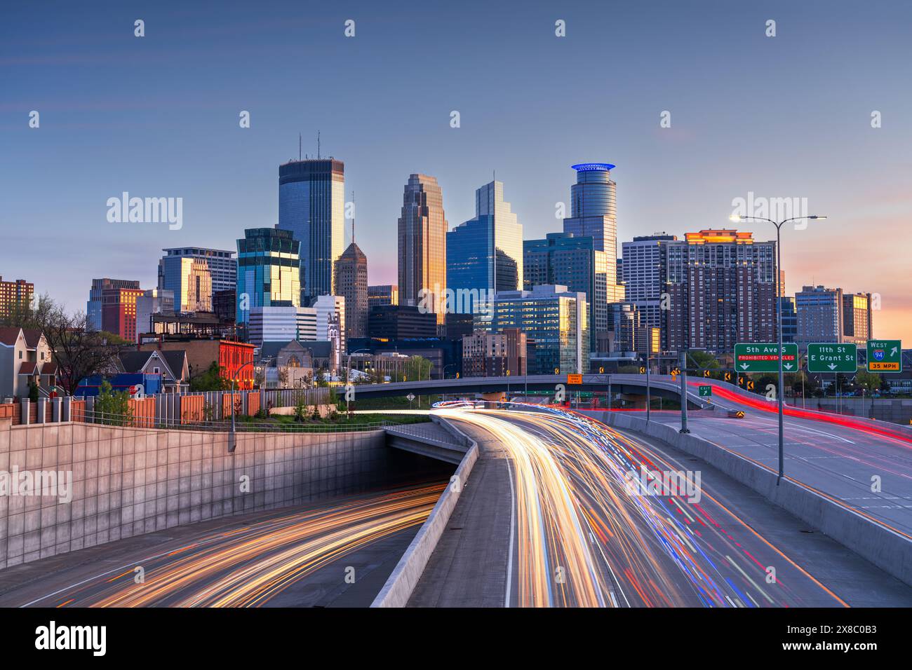 Die Skyline der Innenstadt von Minneapolis, Minnesota, USA über die Highways in der Dämmerung. Stockfoto