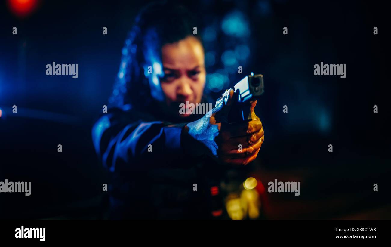 Porträt der schwarzen Polizistin, die mit der Waffe auf Kriminelle zielt, Befehle, die Waffe fallen zu lassen und die Verhaftung zu stoppen. Der Gesetzeshüter bekämpft Verbrechen, verhindert Mord. Kinofilm Stockfoto