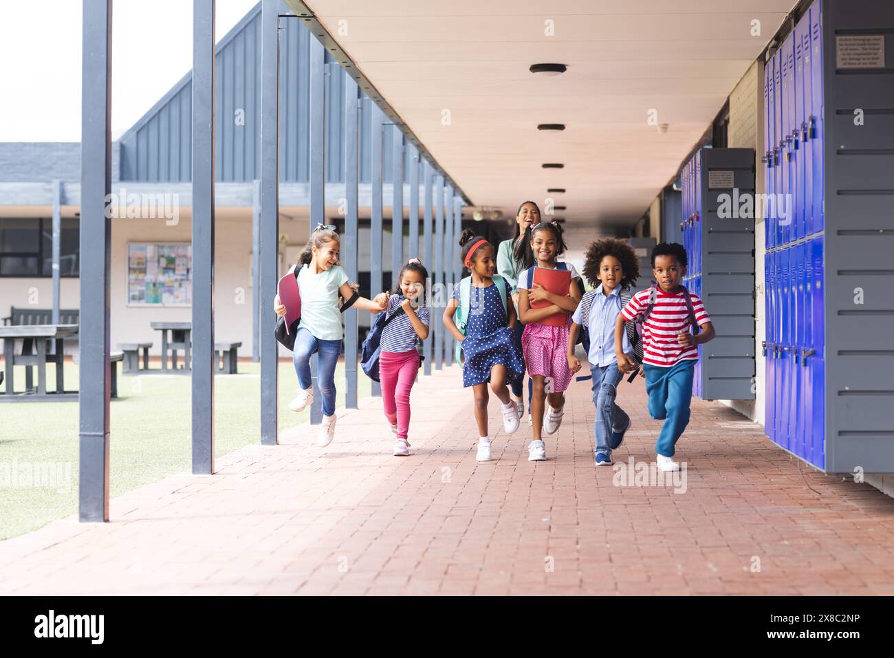 In der Schule läuft eine Gruppe von Schülern im Freien durch einen Flur Stockfoto