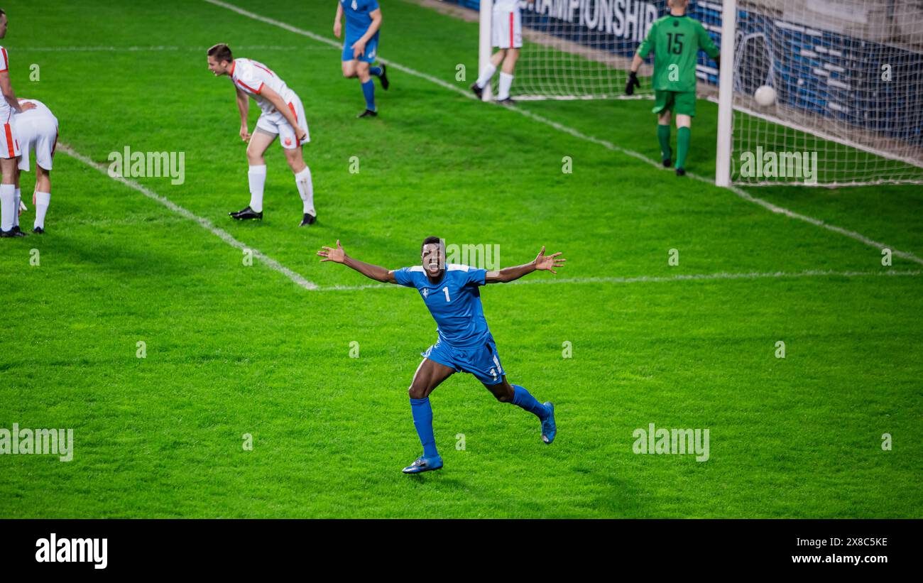 Meisterschaftsspiel: Blue Soccer Team Attack, Player Run Happy After Scoring Goal, Celebre Victory, schaut in die Kamera. Sport Channel Broadcast Tv Konzept. Stockfoto