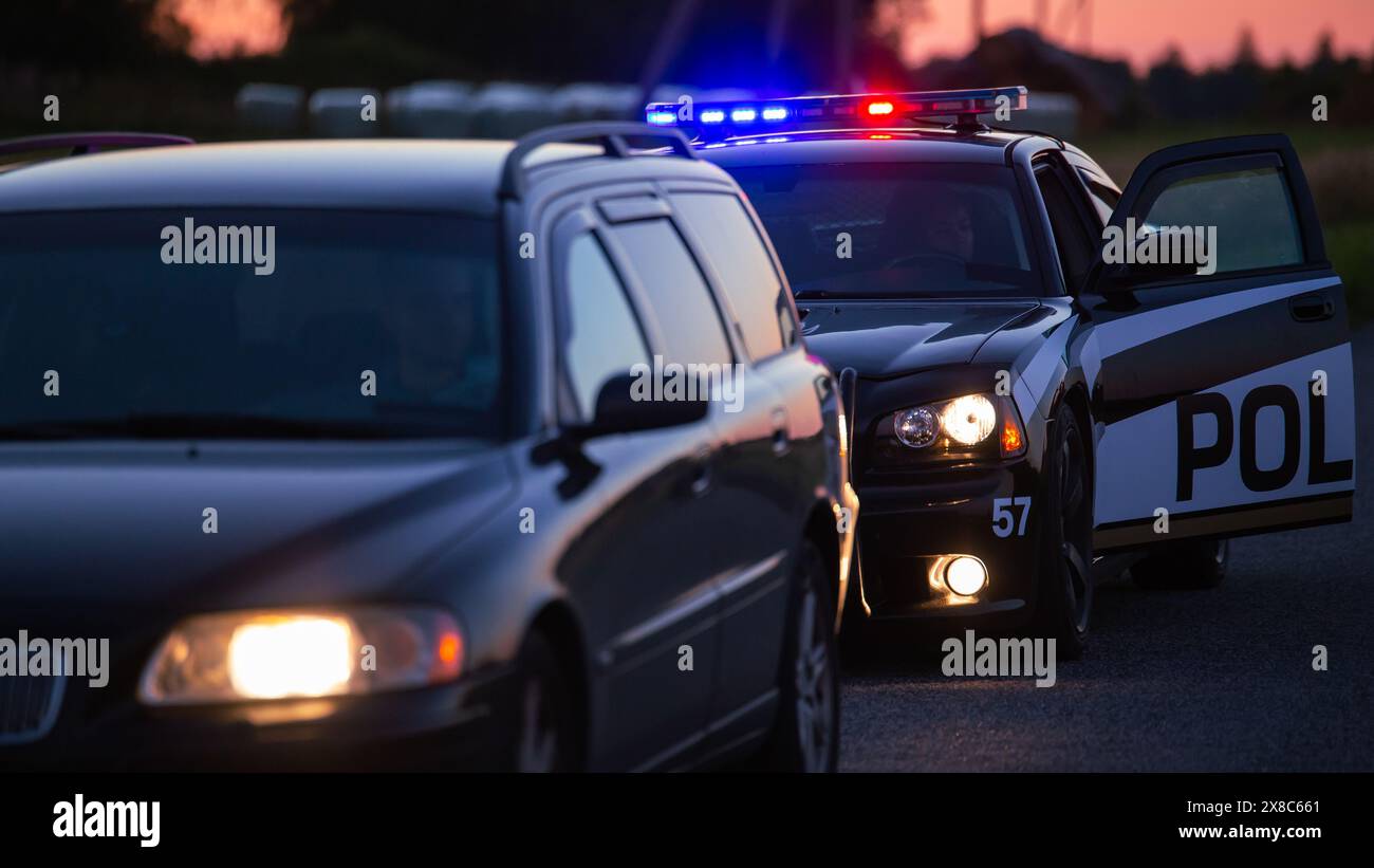 Der Highway Traffic Patrol Car fährt über das Fahrzeug auf der Straße. Der männliche Polizeibeamte kommt und bittet den Fahrer um einen Führerschein und eine Registrierung. Angestellter des Gesetzes, der beruflich Arbeit leistet. Weitwinkelaufnahmen Im Kinoformat Stockfoto