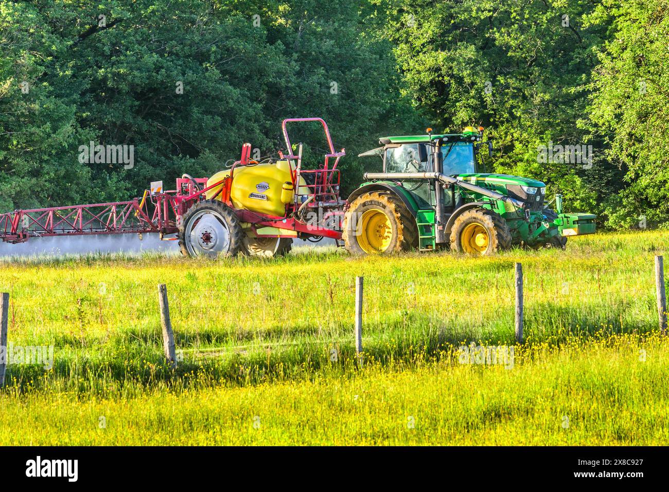 John Deere 6140R-Traktor schleppt eine Feldspritze für die Unkrautvernichtung von Hardi Commander – Bossay-sur-Claise, Indre-et-Loire (37), Frankreich. Stockfoto