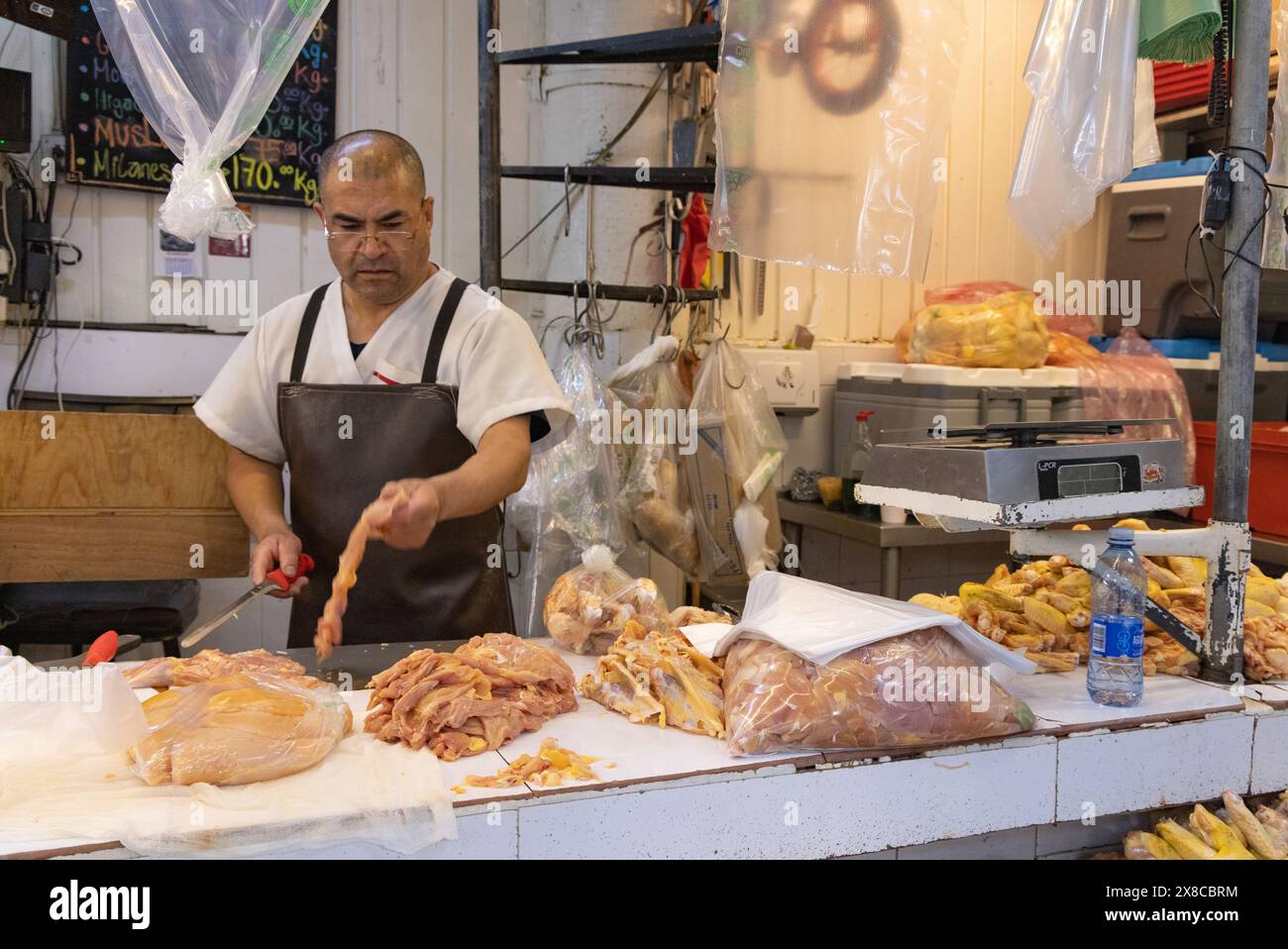 Mexico City Market; Ein Metzger hackt Huhn an seinem Fleischstand, San Juan Indoor Food Market, Mexico City, Mexiko Stockfoto